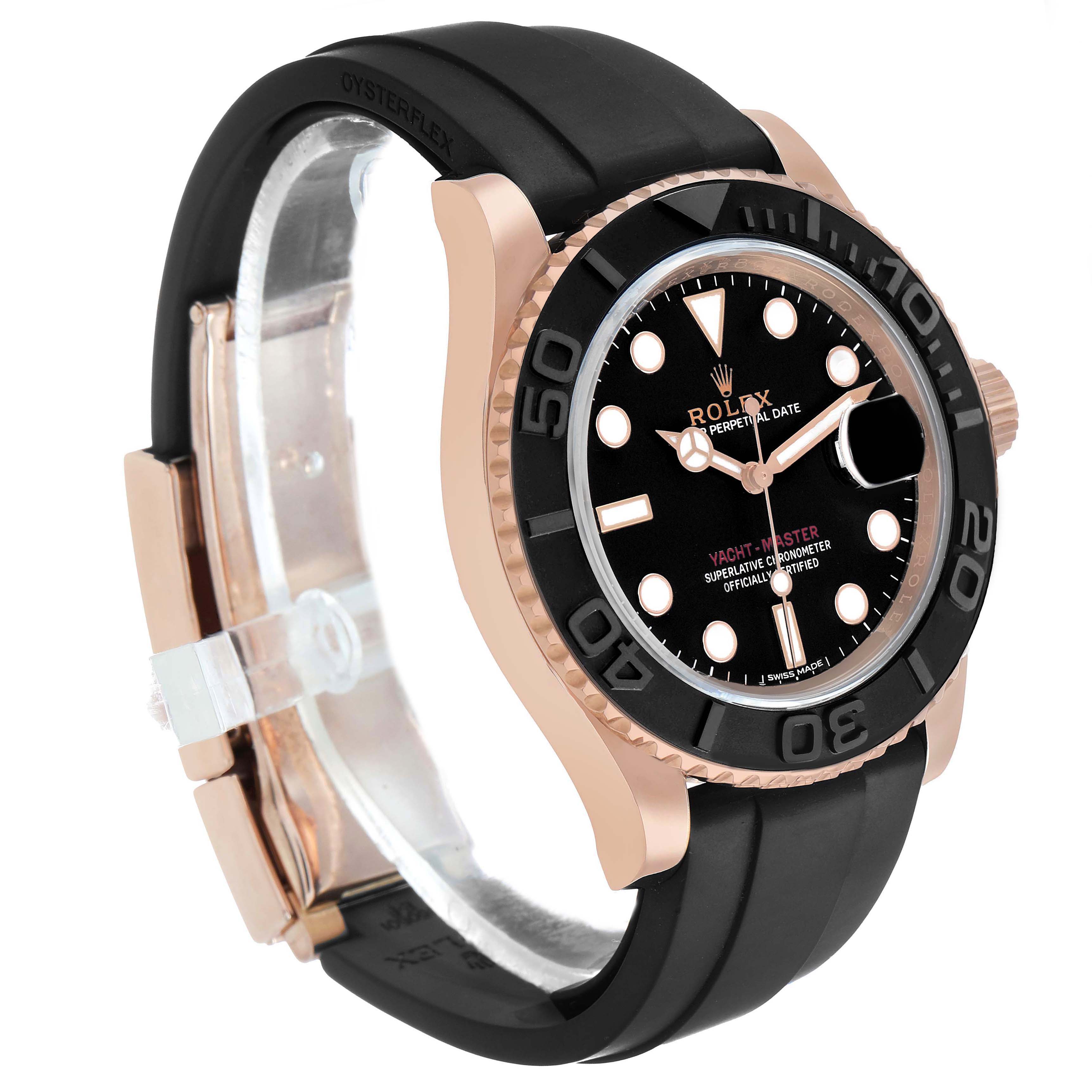 The Rolex Yacht-Master 116655 Men's Rose Gold Black Dial watch is shown at a three-quarter angle, highlighting its black dial, rose gold case, and black strap.