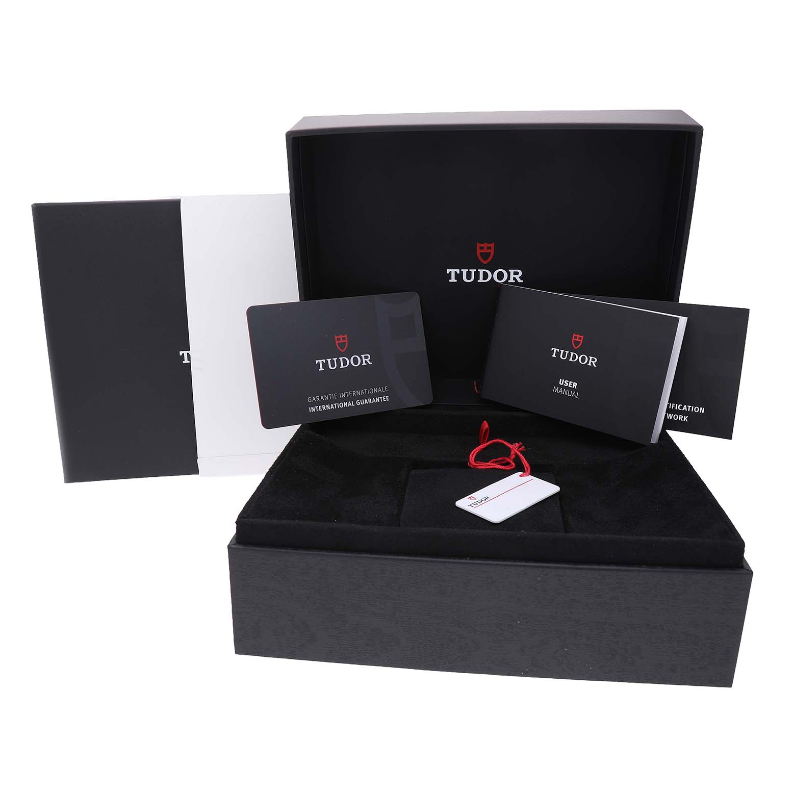 The image shows the packaging and documents for the Tudor Heritage Black Bay 79030B Men's Stainless Steel Blue Dial, including a box, tags, and manuals.