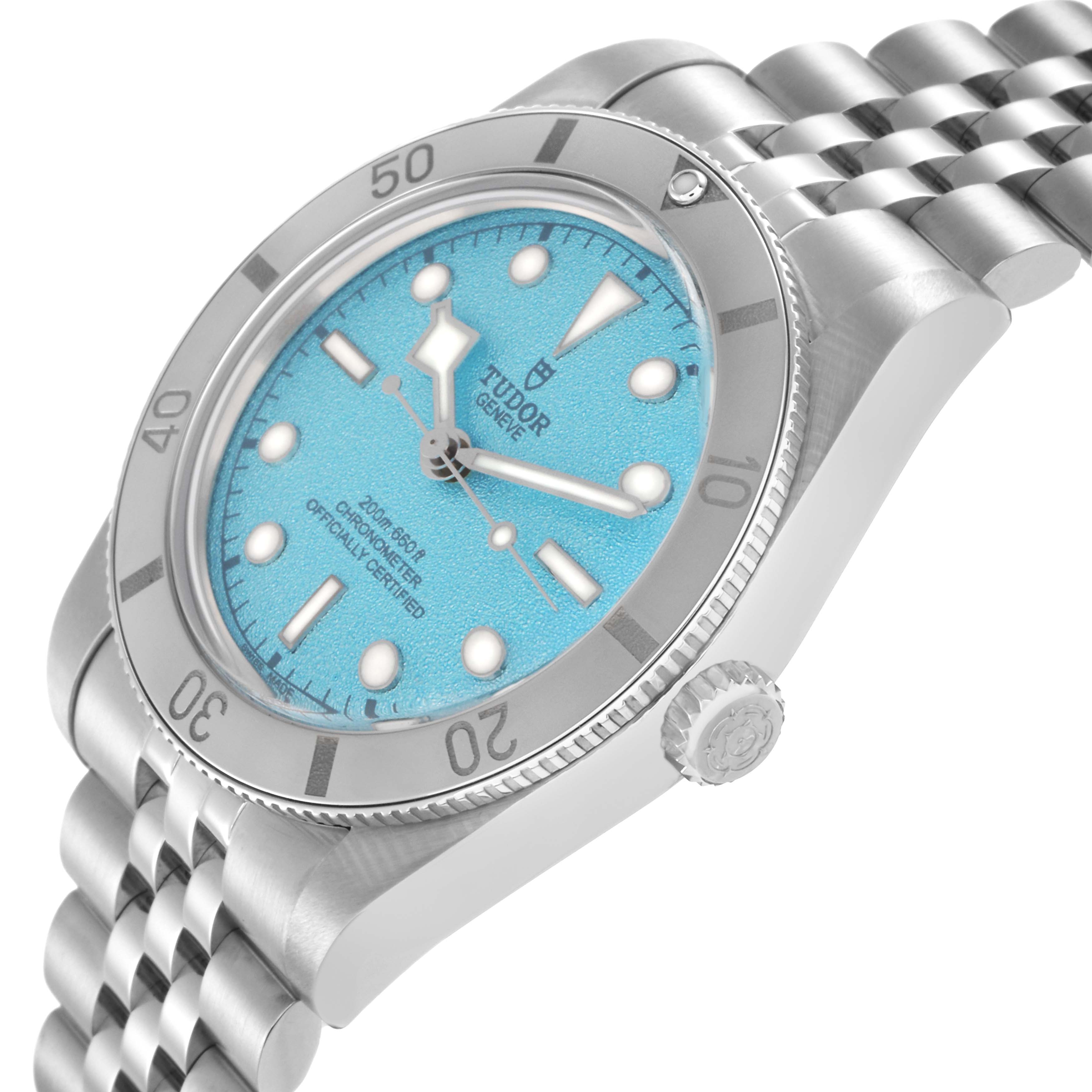 The Tudor Heritage Black Bay model 79000 is shown from a side angle, highlighting the blue dial, bezel, and crown with part of the bracelet visible.