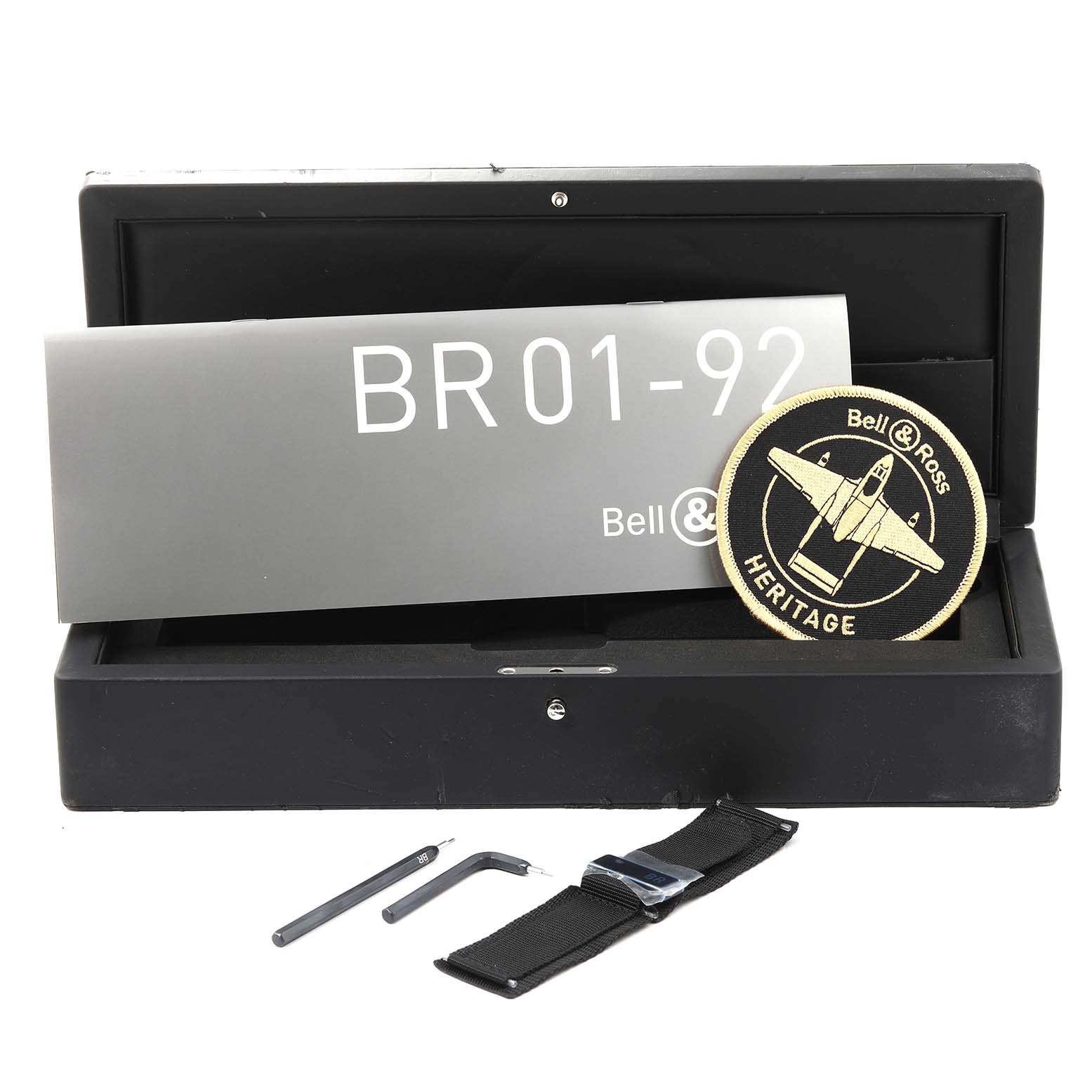 The image shows a Bell & Ross Heritage BR01-92-S Men's Stainless Steel Black Dial BR01-92-S Men's Stainless Steel Black Dial BR01-92 watch box, booklet, patch, spare strap, and tools.