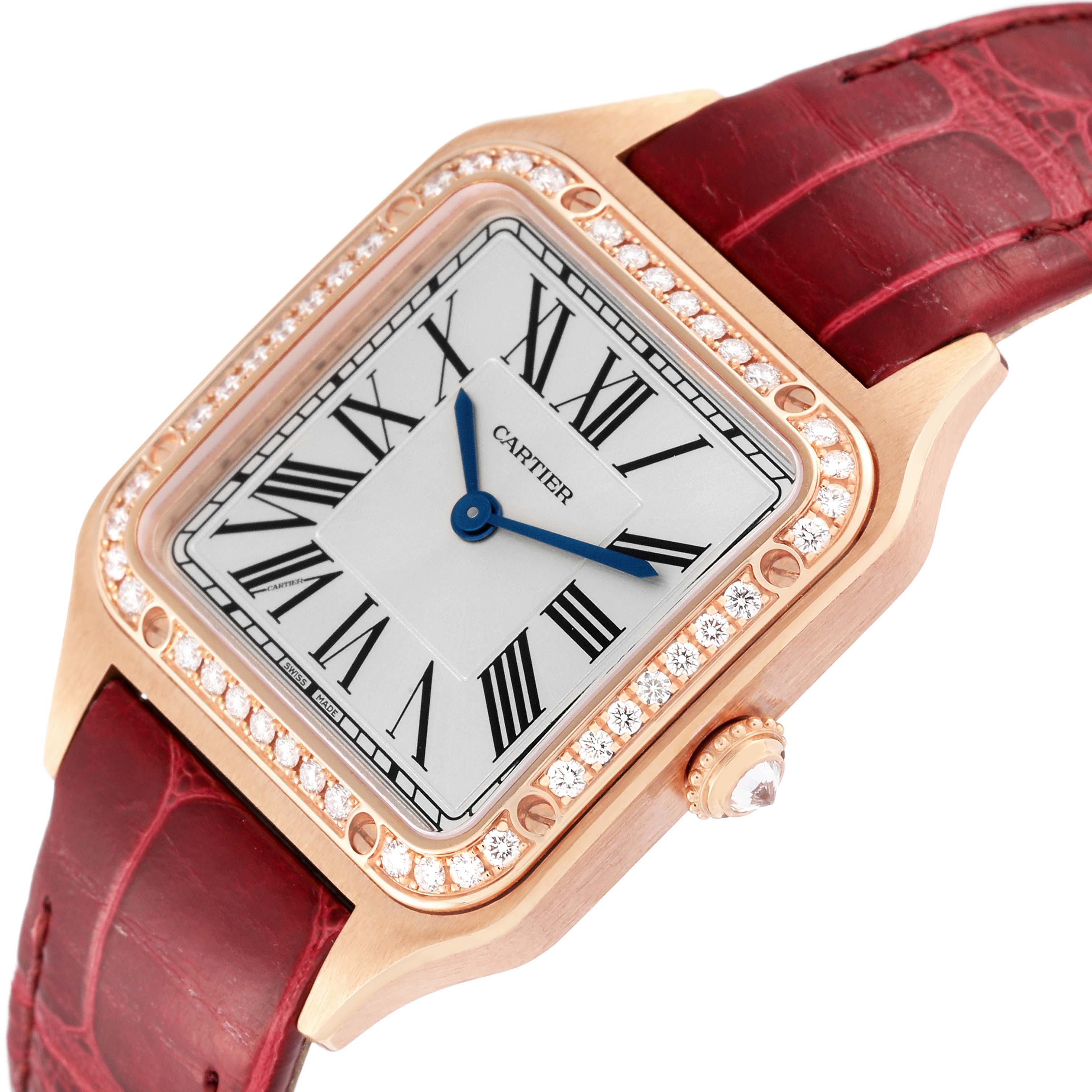 This image shows a close-up of the Cartier Santos WJSA0017 Women's Rose Gold Silver Dial WJSA0017 Women's Rose Gold Silver Dial model watch, highlighting its bezel, dial, and red leather strap at an angled view.