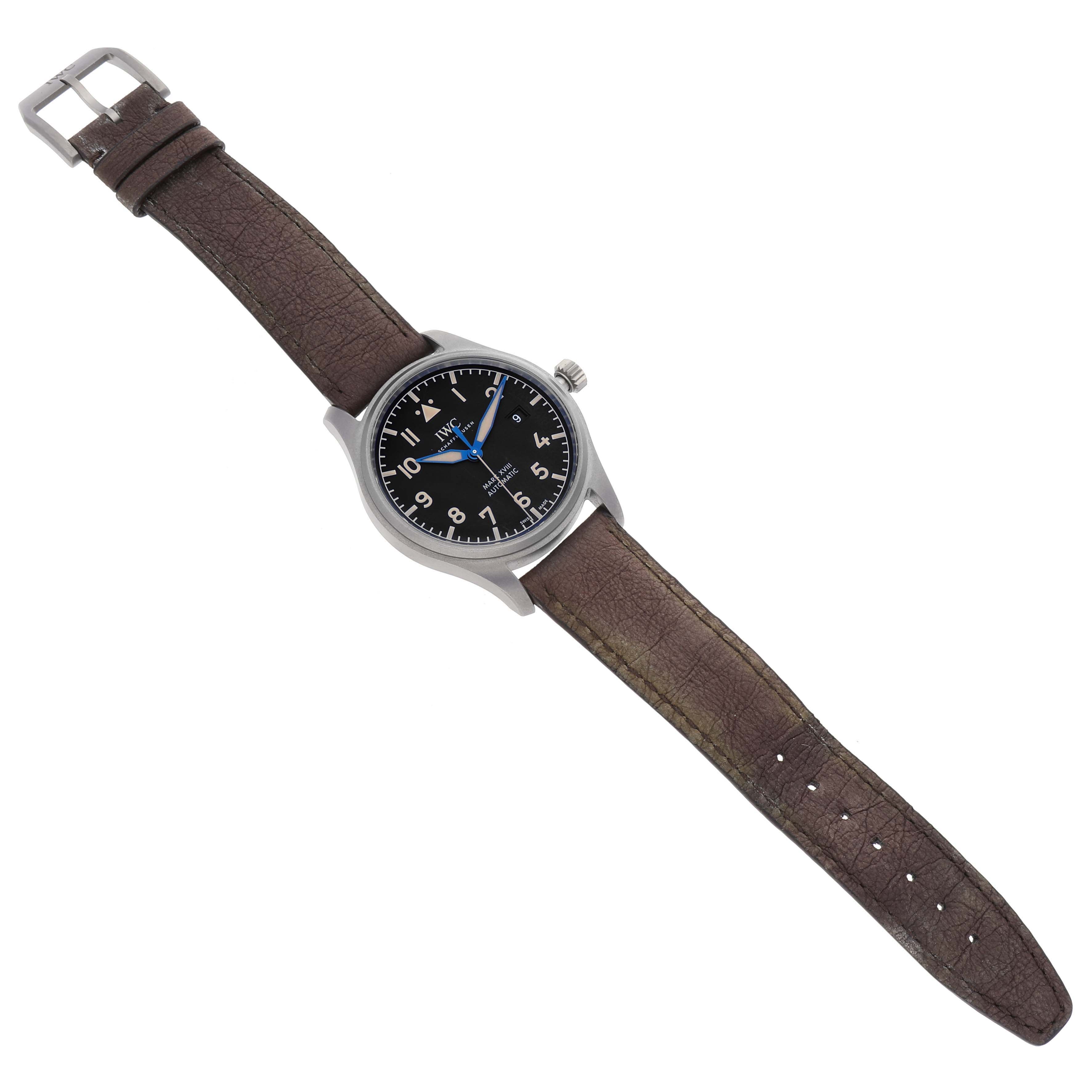 The image shows the IWC Pilot IW327006 Men's Titanium Black Dial IW327006 Men's Titanium Black Dial watch laid flat, displaying the brown leather strap, black dial, and silver case from a top view.