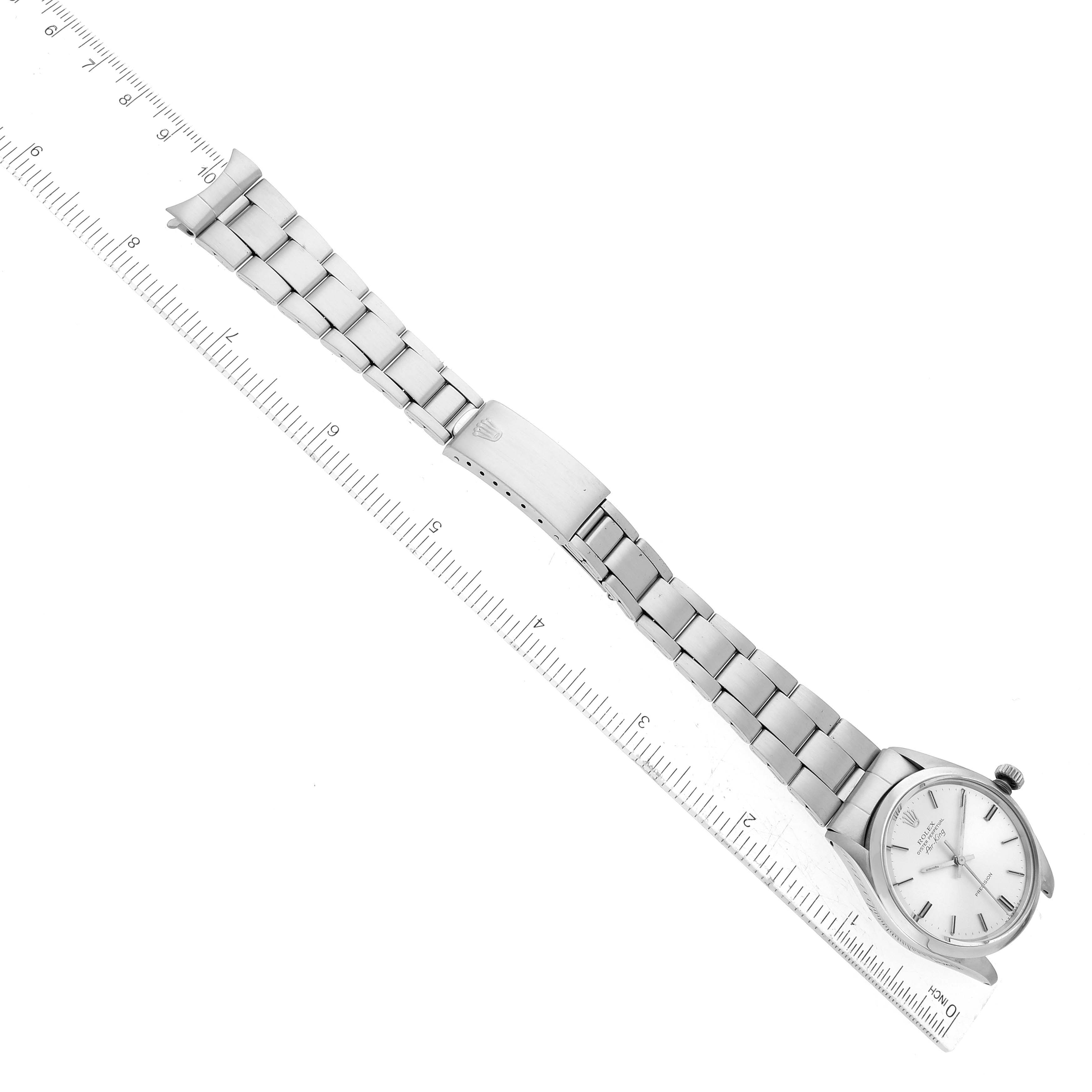 The image shows a top-down view of a Rolex Vintage Collection 5500 Men's Stainless Steel Silver Dial 5500 Men's Stainless Steel Silver Dial model watch with its stainless steel bracelet laid next to a ruler.