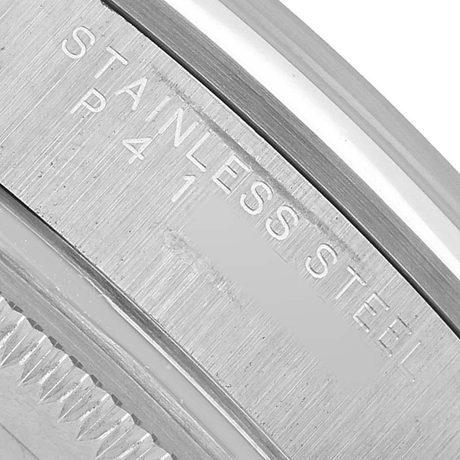 The image shows a close-up of the rim and bezel area of a Rolex Date 15200 Men's Stainless Steel Pink Dial model, highlighting the engraved "STAINLESS STEEL".