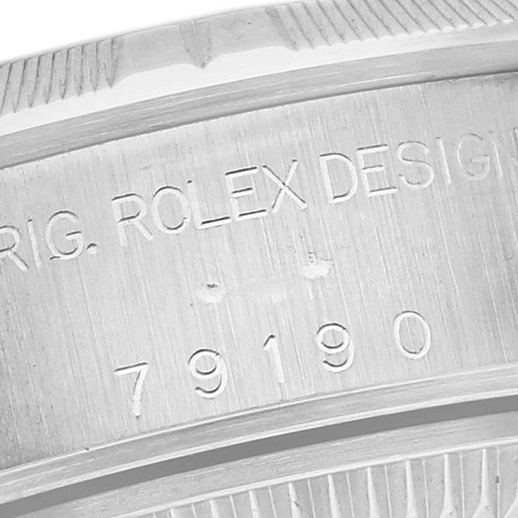 The image shows a close-up of the side engraving on a Rolex Date 79190 Women
s Stainless Steel White Dial 79190 Women
s Stainless Steel White Dial model watch, displaying the serial number and design details.