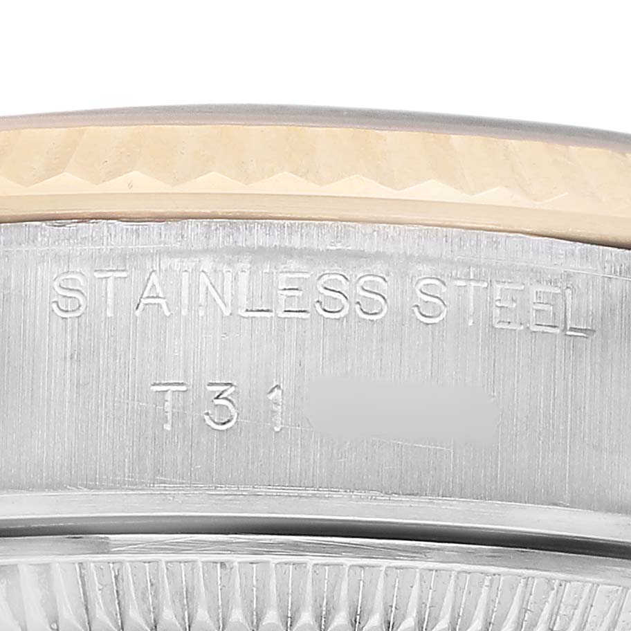The image shows a close-up of the Rolex Datejust 69173 Women's Steel and Gold (two tone) Champagne Dial's case edge and bezel, displaying "STAINLESS STEEL" engravings.