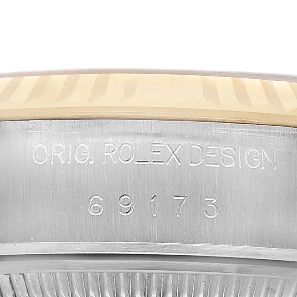 The image shows a close-up of the Rolex Datejust 69173 Women's Steel and Gold (two tone) Champagne Dial model's side, highlighting the serial number and design engraving.