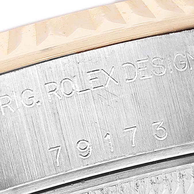 The image shows a close-up of the Rolex Datejust 79173 Women's Steel and Gold (two tone) White Dial model's engraved inner bezel and reference number.