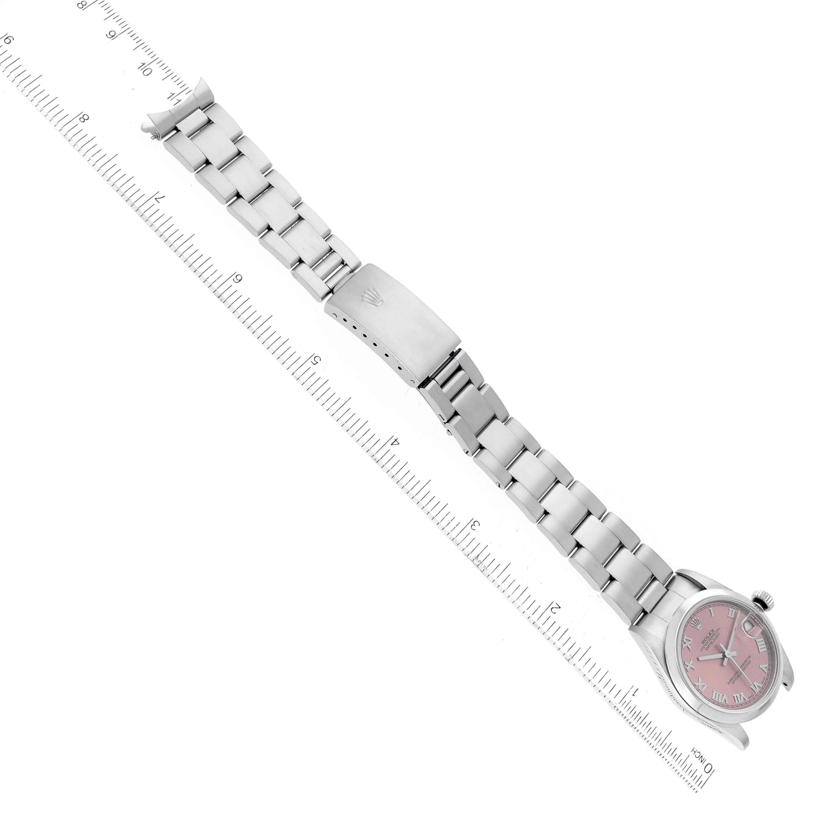 The image shows a top-down view of a Rolex Mid-Size 78240 Women's Stainless Steel Pink Dial 78240 Women's Stainless Steel Pink Dial watch, displaying its band, clasp, and face, next to a ruler for scale.