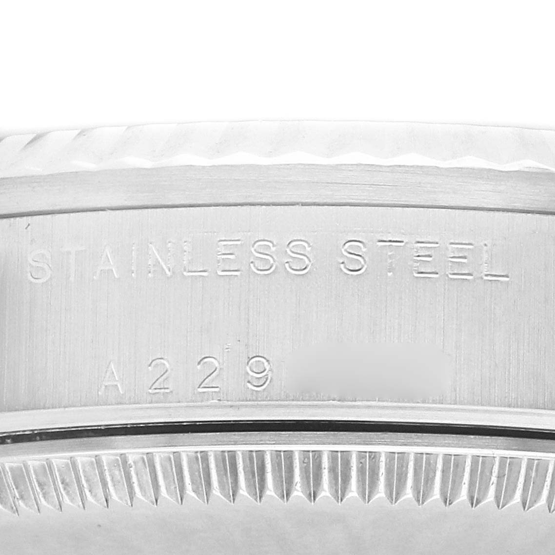 The image shows a close-up side view of the case edge on a Rolex Mid-Size model 78274, highlighting the "STAINLESS STEEL" engraving.