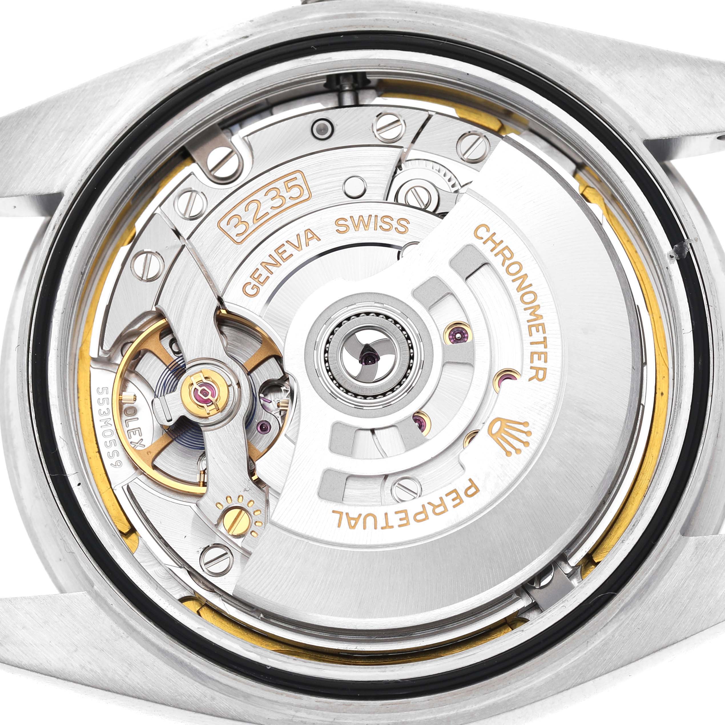The image shows the movement of a Rolex Datejust 41 126300 Men's Stainless Steel White Dial watch from the back, highlighting its intricate mechanisms and engravings.