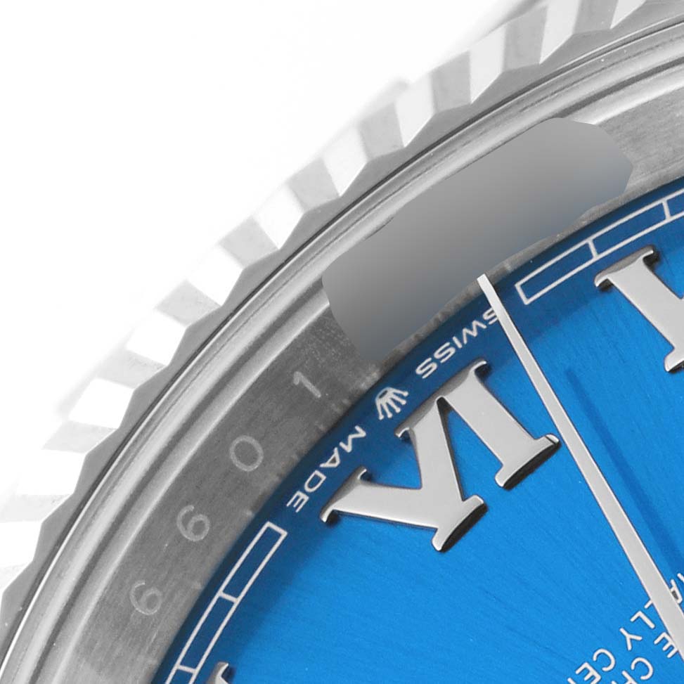 The image shows a close-up of the dial and fluted bezel of a Rolex Datejust 41 126334 Men's Stainless Steel Blue Dial 126334 Men's Stainless Steel Blue Dial watch, highlighting the Roman numerals and part of the minute hand.