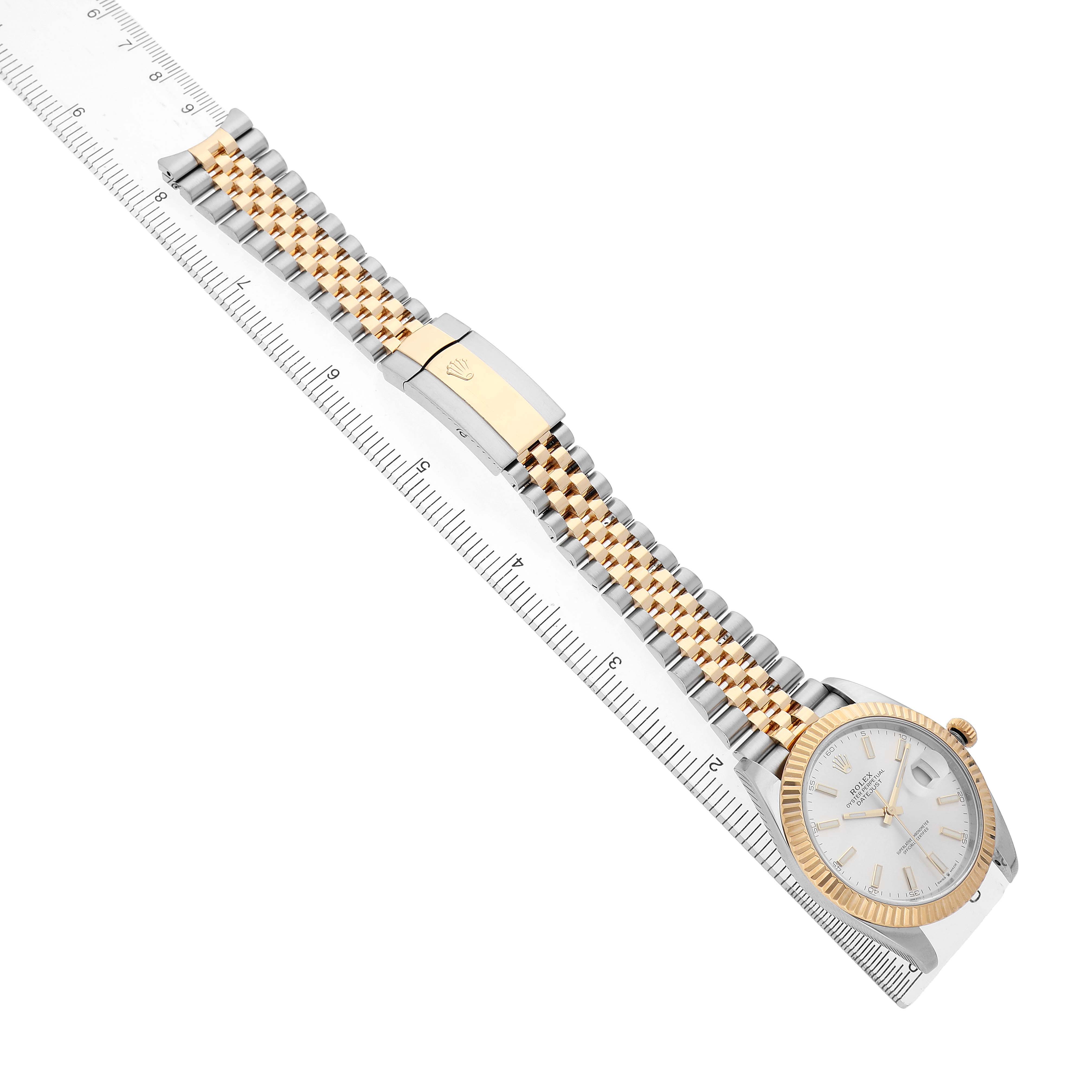 The Rolex Datejust 41 126333 Men's Steel and Gold (two tone) Silver Dial is shown from a diagonal top view highlighting the face, bezel, and Jubilee bracelet on a ruler.
