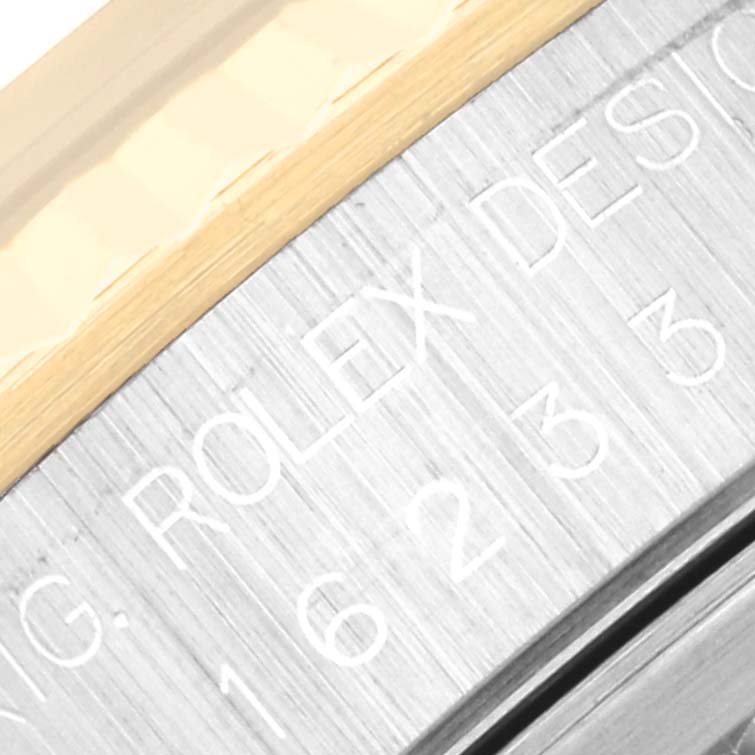 Close-up of the engraved side of a Rolex Datejust 16233 Men's Steel and Gold (two tone) Blue Dial 16233 Men's Steel and Gold (two tone) Blue Dial watch, displaying part of the outer casing.