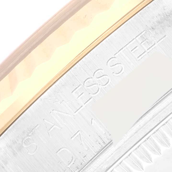 The image shows a close-up of the edge of a Mid-Size Rolex watch case, featuring stainless steel and part of the bezel.