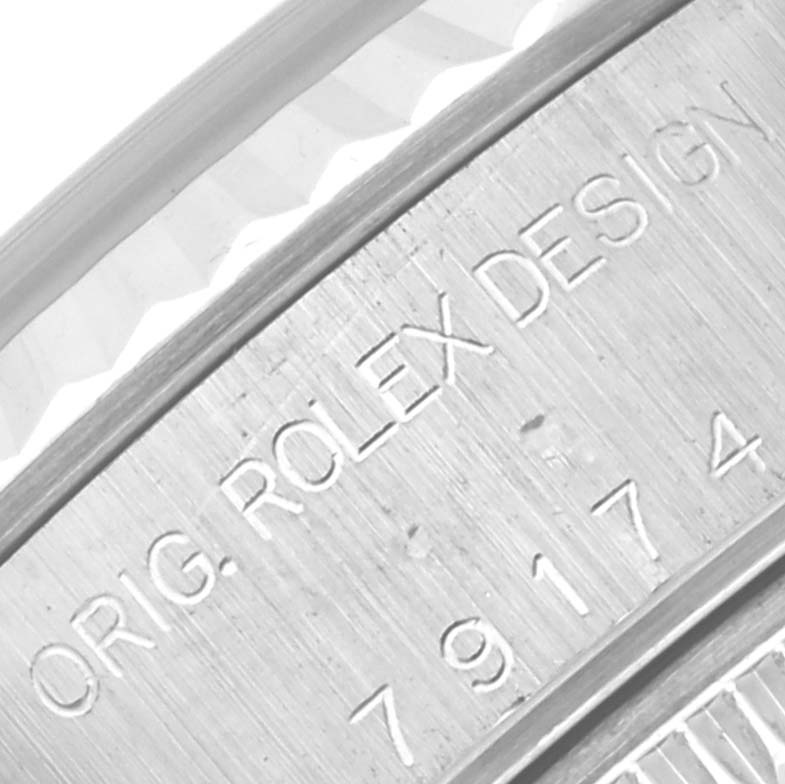 This close-up photo shows the engraved text on the caseback edge of a Rolex Datejust 79174 Women's Stainless Steel Mother of Pearl Dial 79174 Women's Stainless Steel Mother of Pearl Dial watch.