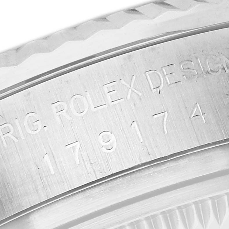 This image shows the engraved side of the bezel from a Rolex Datejust 179174 Women's Stainless Steel Silver Dial 179174 Women's Stainless Steel Silver Dial watch with visible serial numbers and text.