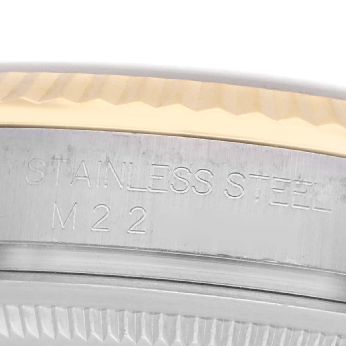The image shows a close-up of the bezel and side engraving of the Rolex Datejust model 116233, highlighting the "STAINLESS STEEL M22" text.