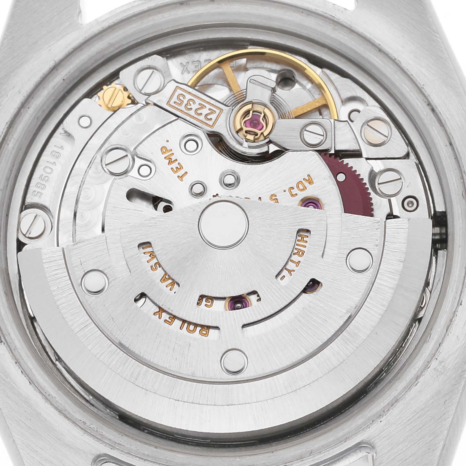 The image shows a close-up of the movement inside a Rolex Datejust model, number 179173, highlighting gears, screws, and the rotor from a top-down angle.