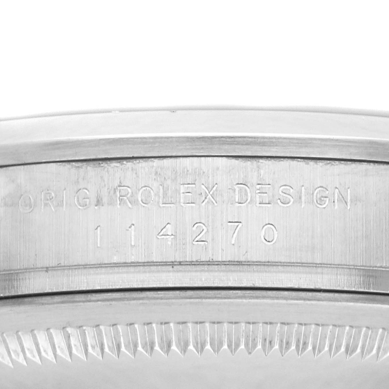 The image shows a close-up of the side of a Rolex Explorer watch, model number 114270, featuring the engraved text "ORIG ROLEX DESIGN 114270."