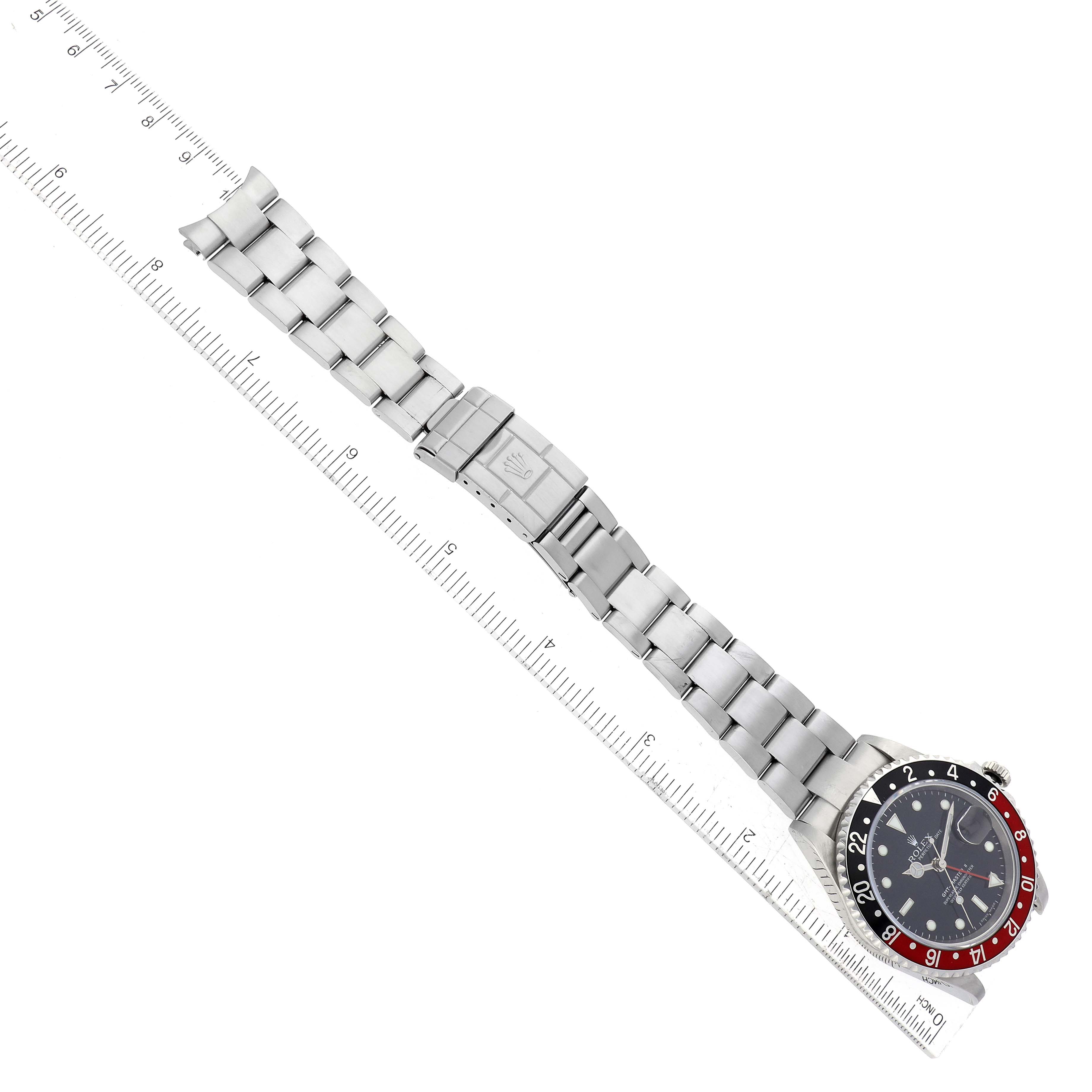 The image shows a Rolex GMT-Master 16710 Men's Stainless Steel Black Dial 16710 Men's Stainless Steel Black Dial watch laid flat next to a ruler, displaying its bracelet, clasp, case, and bezel.
