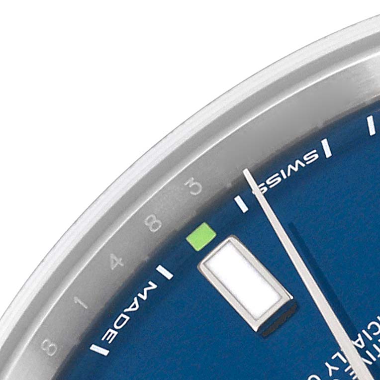 This close-up of the Rolex Oyster Perpetual 114300 Men
s Stainless Steel Blue Dial 114300 Men
s Stainless Steel Blue Dial shows a portion of the dial with minute markers, a luminescent hour marker, and the watch
s hand.