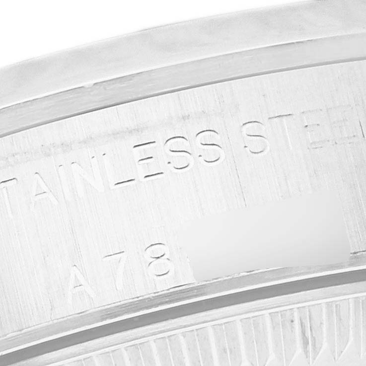 The image shows a close-up of the engraved stainless steel part of a Rolex Oyster Perpetual 76080 Women's Stainless Steel Pink Dial 76080 Women's Stainless Steel Pink Dial watch.