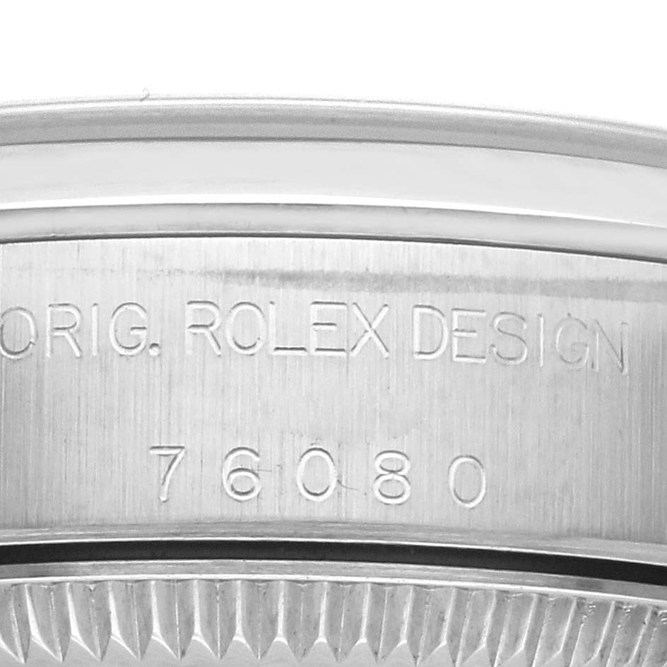 This image shows a close-up of the side engraving on a Rolex Oyster Perpetual 76080 Women's Stainless Steel Black Dial 76080 Women's Stainless Steel Black Dial, featuring "ORIG. ROLEX DESIGN" and the model number "76080."