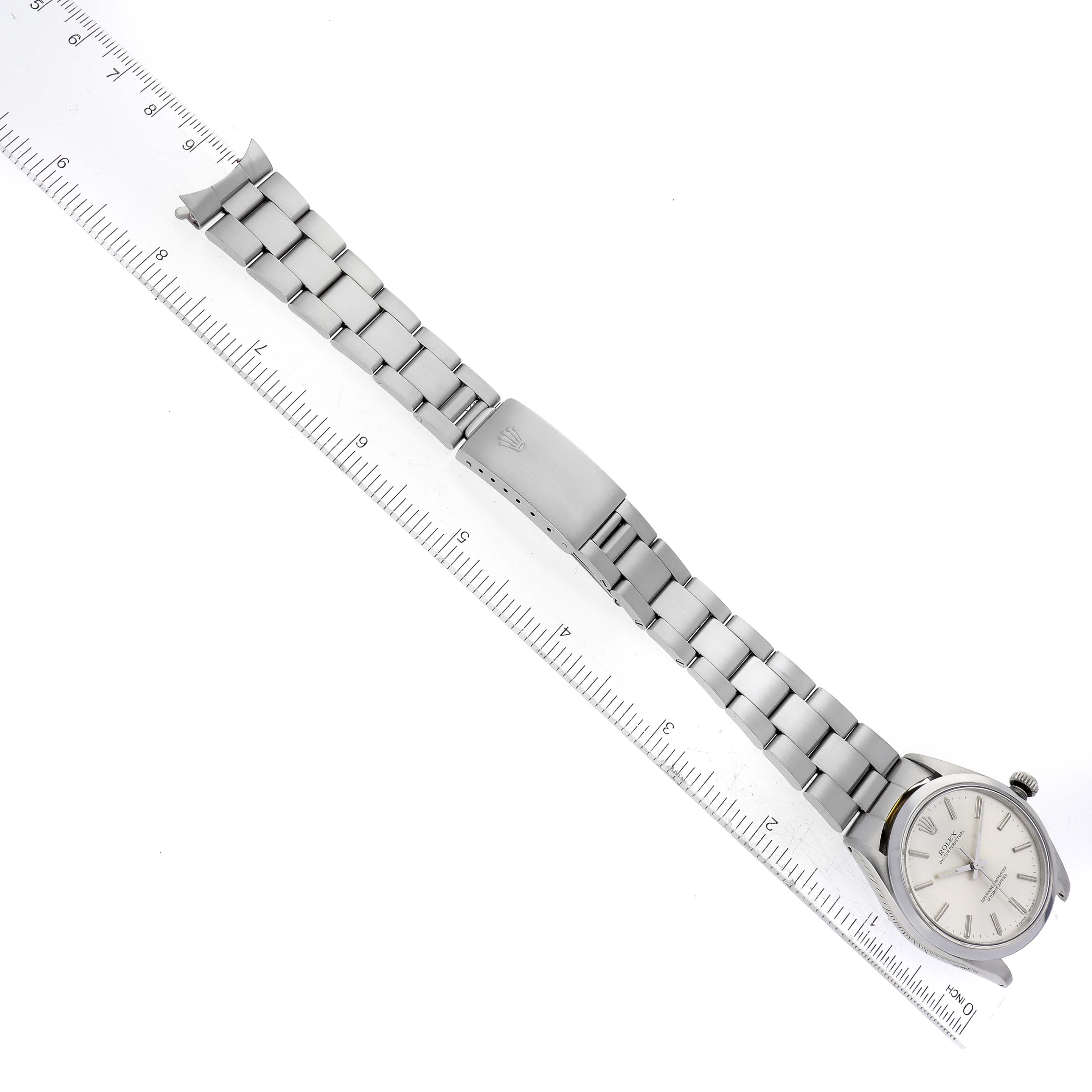 The image shows a top-down view of a Rolex Vintage Collection 1002 Men's Stainless Steel Silver Dial 1002 Men's Stainless Steel Silver Dial watch, displaying its face, bracelet, and ruler for measurement.