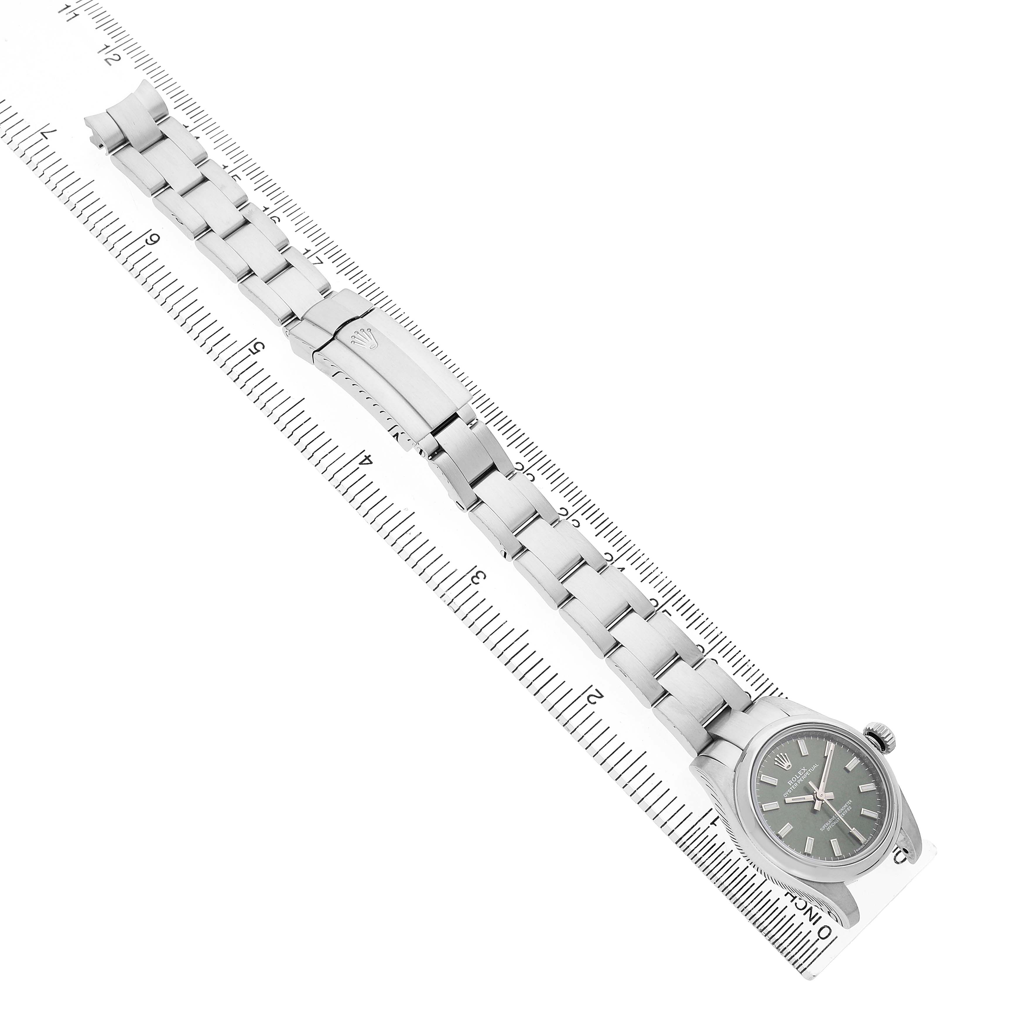 The Rolex Oyster Perpetual 176200 Women's Stainless Steel Green Dial watch is shown from an overhead angle, highlighting the face, bracelet, and clasp along a ruler.