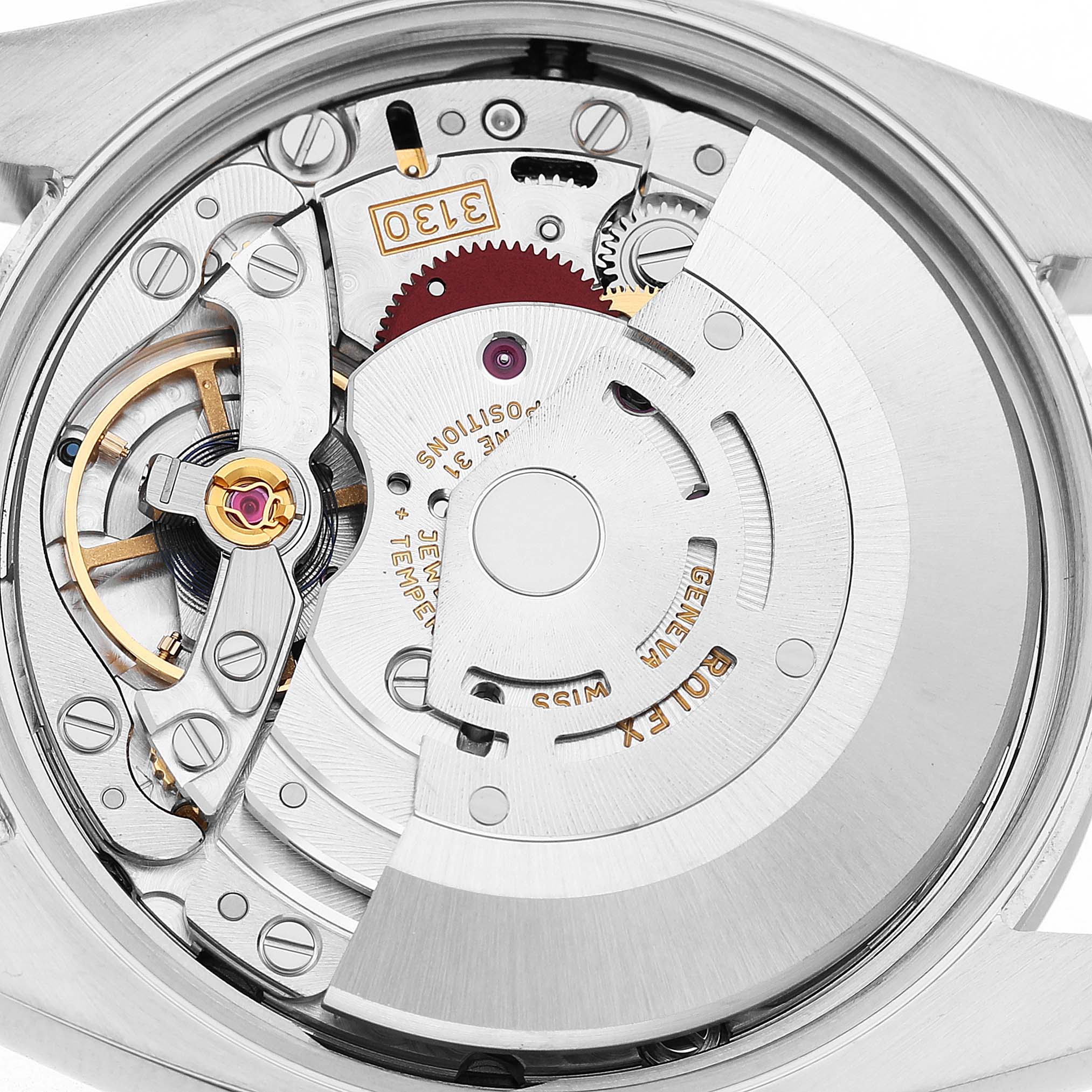 The image shows the movement mechanism of a Rolex Oyster Perpetual 114200 Men's Stainless Steel Green Dial watch from a back angle.