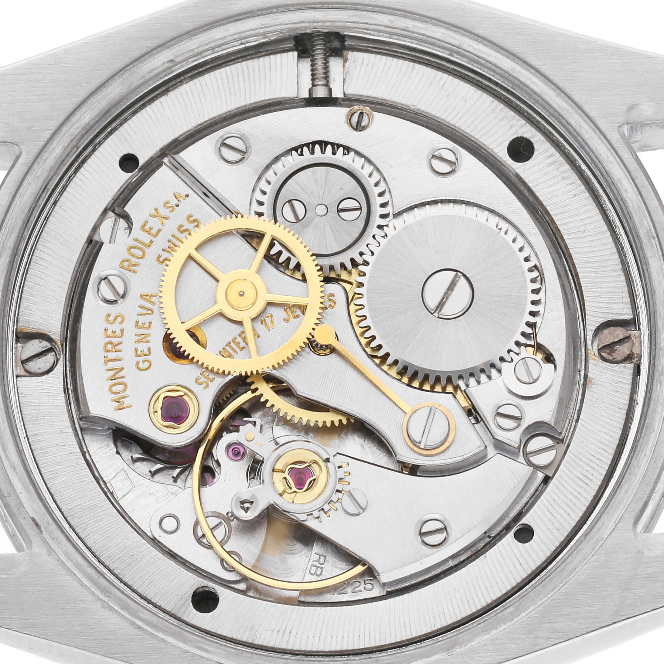 The image shows the movement mechanism of a Rolex Date model watch, model number 6694, featuring gears and components from a top-down angle.