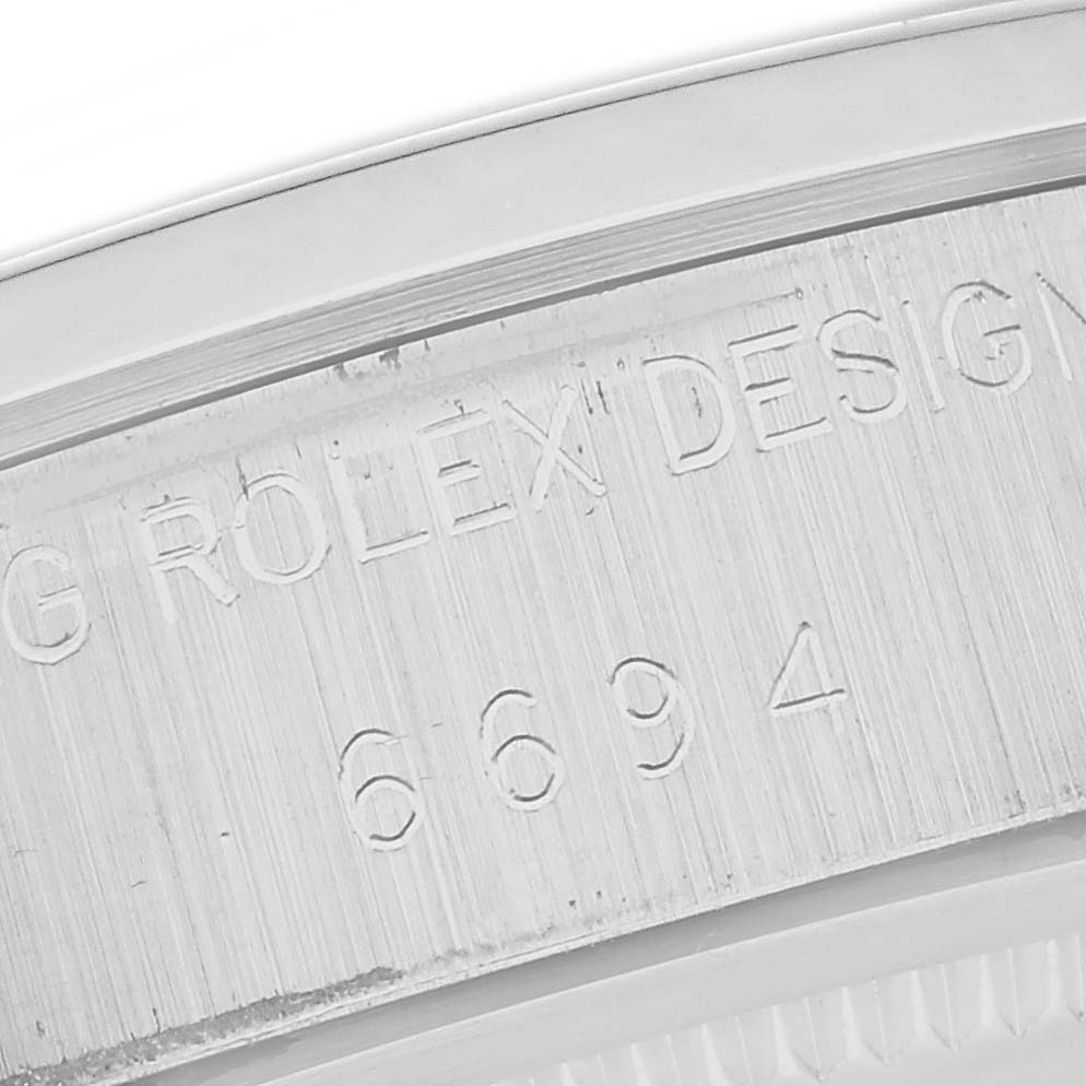 The image shows a close-up of the case back edge, displaying the model number and "ROLEX DESIGN" text of the Vintage Collection watch by Rolex.