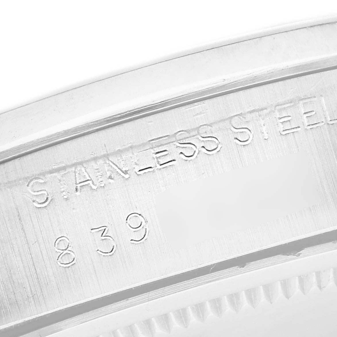 This close-up image shows the engraved "STAINLESS STEEL" text and serial number on the side of a Vintage Collection Rolex watch case.