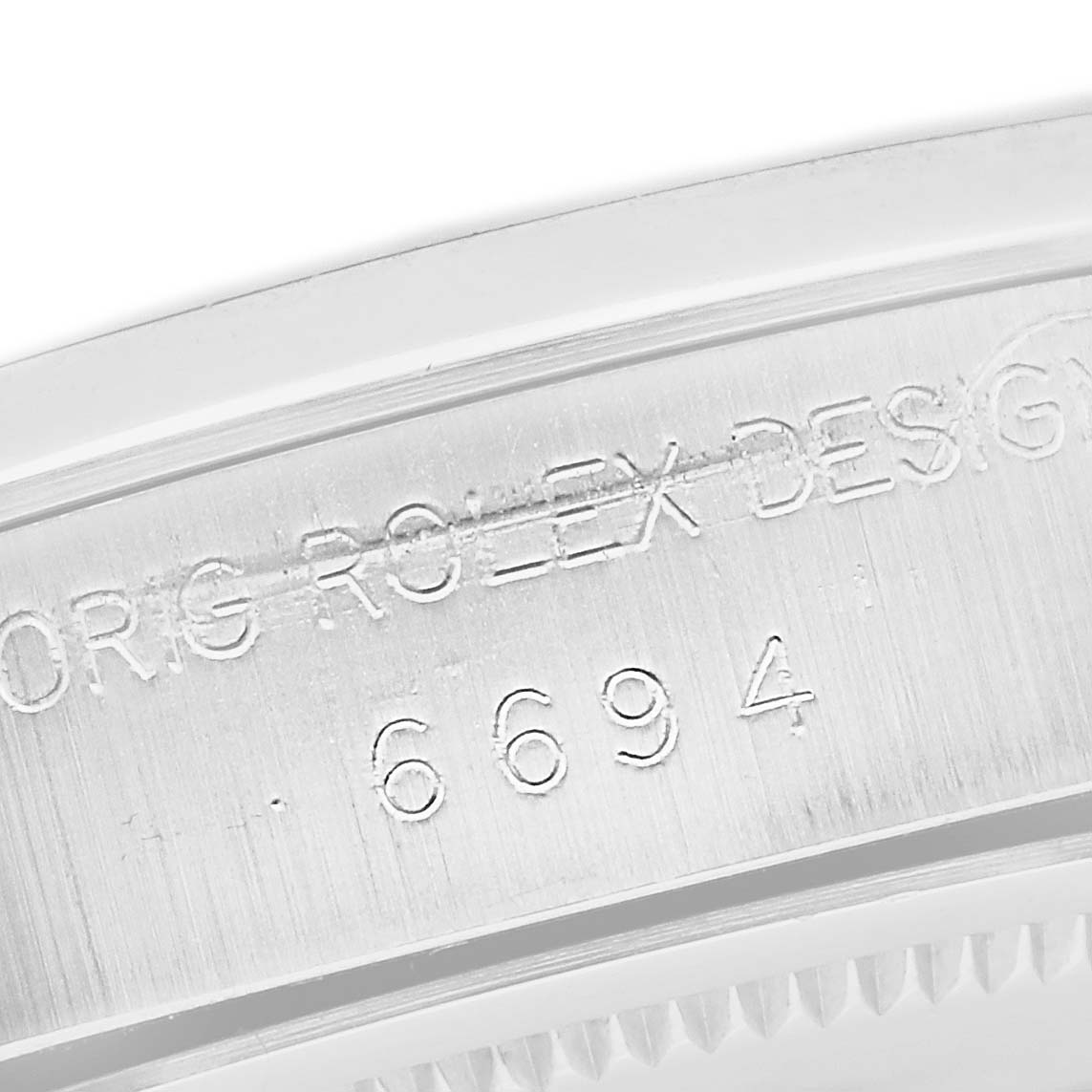 This close-up image shows the engraved serial numbers on the side of the bezel of a Rolex Vintage Collection 6694 Men's Stainless Steel Silver Dial 6694 Men's Stainless Steel Silver Dial model.