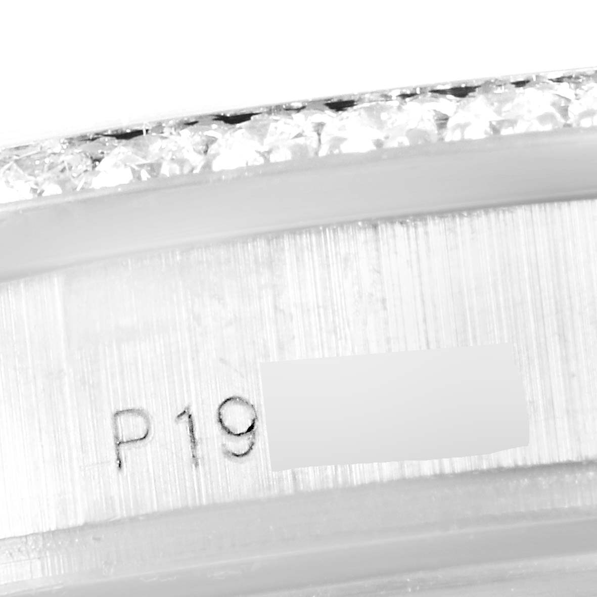 The image shows a close-up of the serial number on the bezel of a Rolex President 18346 Men's White Gold Silver Dial 18346 Men's White Gold Silver Dial model watch.