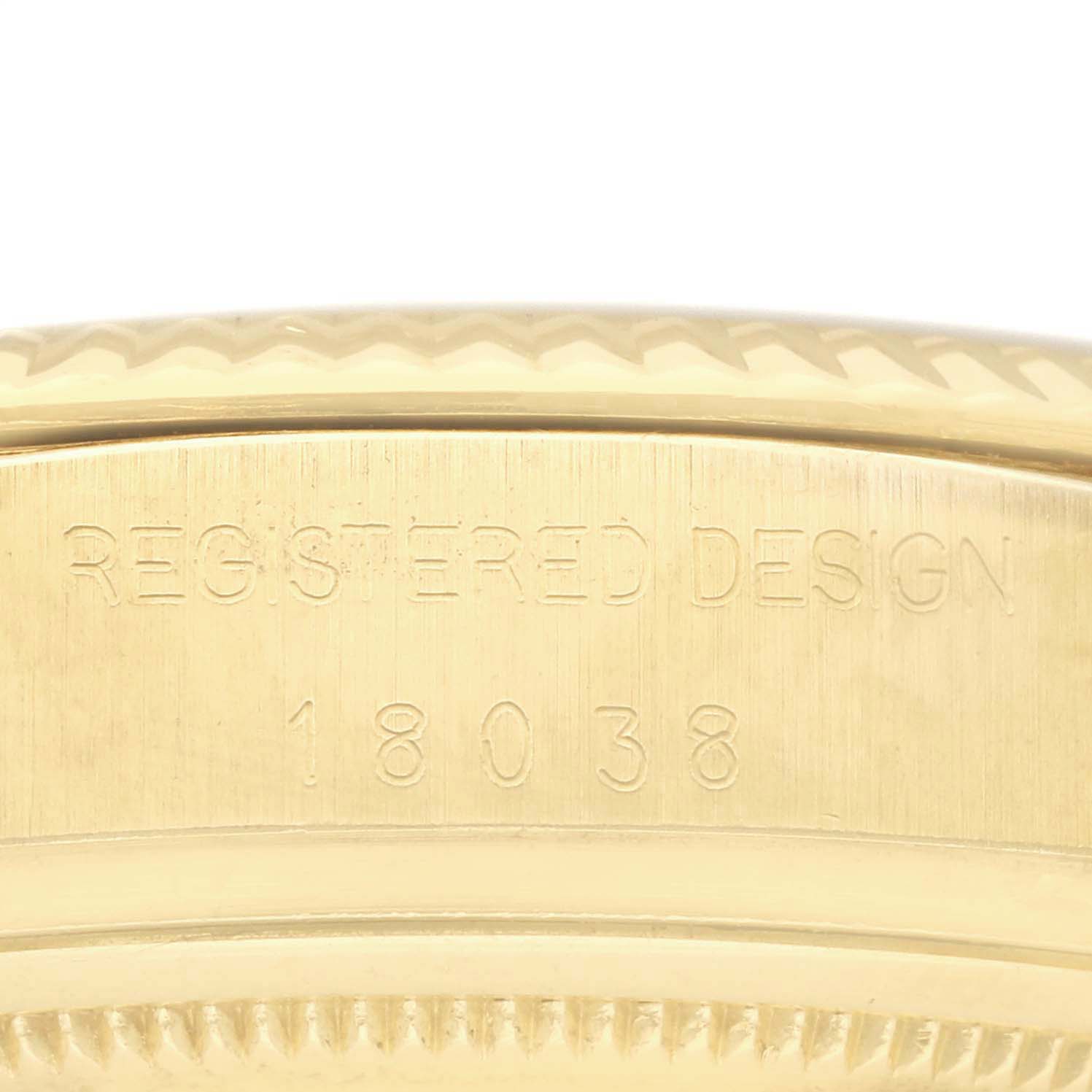 This close-up image shows the model number 18038 and "REGISTERED DESIGN" engraving on a gold Rolex President 18038 Men's Yellow Gold Black Dial 18038 Men's Yellow Gold Black Dial watch case.