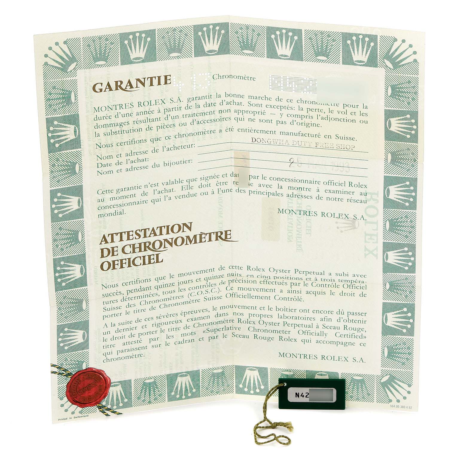 The image shows the warranty certificate for a Rolex Submariner, model number 16610, with its official chronometer certification and a connected tag.