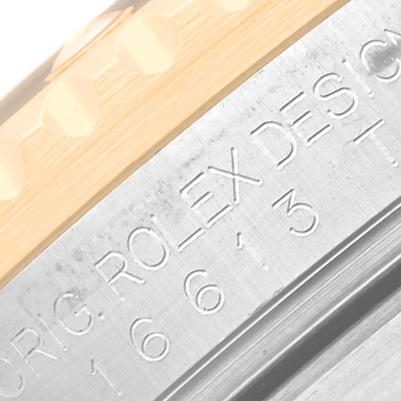 The image shows a close-up of the side engraving on the case of a Rolex Submariner 16613 Men's Steel and Gold (two tone) Black Dial 16613 Men's Steel and Gold (two tone) Black Dial watch, displaying the model number and branding.
