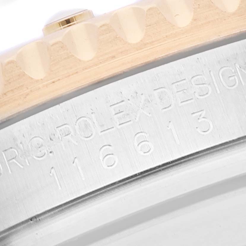 The image displays a close-up view of the engraved edge and bezel teeth of a Rolex Submariner 116613 Men
s Steel and Gold (two tone) Blue Dial 116613 Men
s Steel and Gold (two tone) Blue Dial watch.