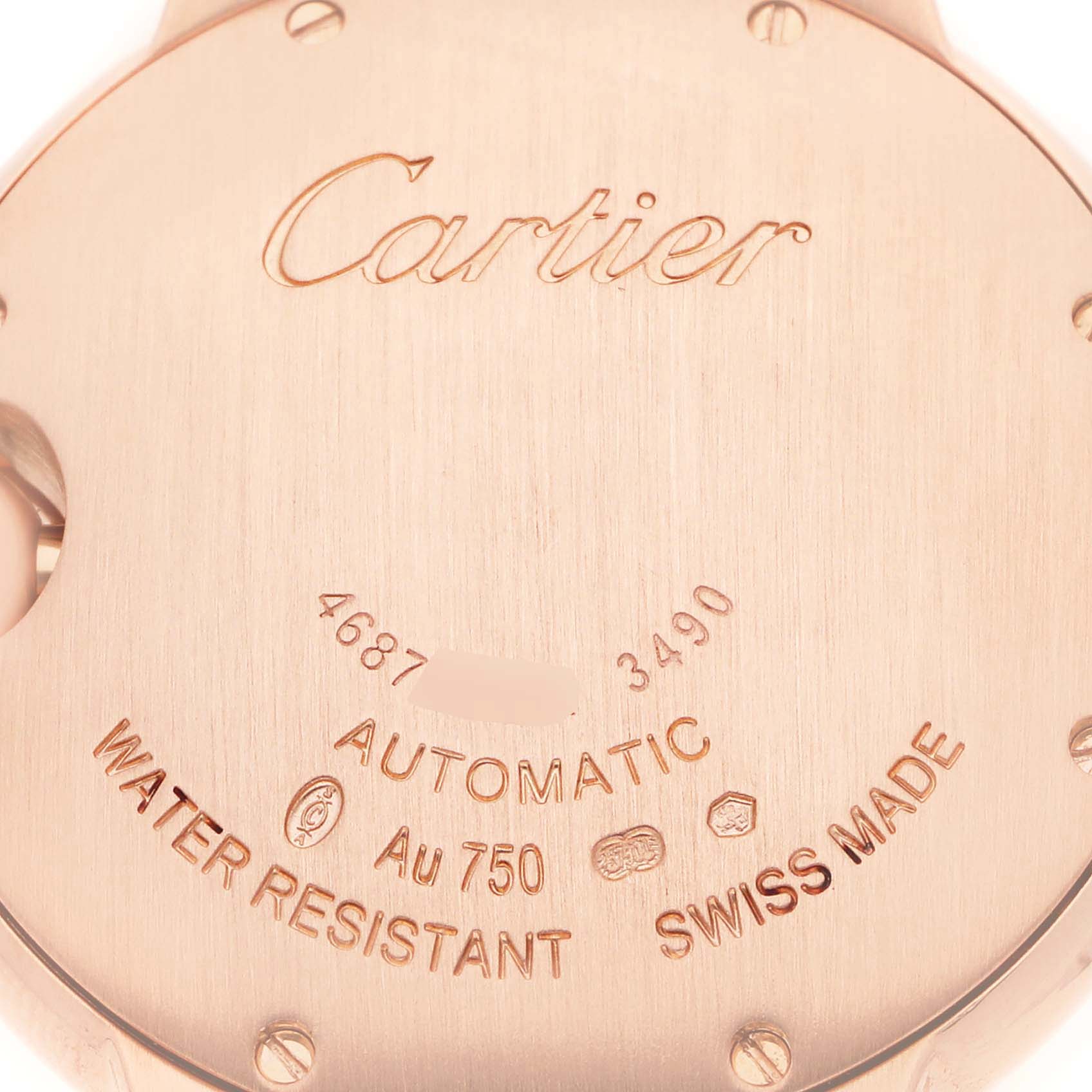 The image shows the back case of a Ballon Bleu by Cartier, featuring engravings and screw markings.