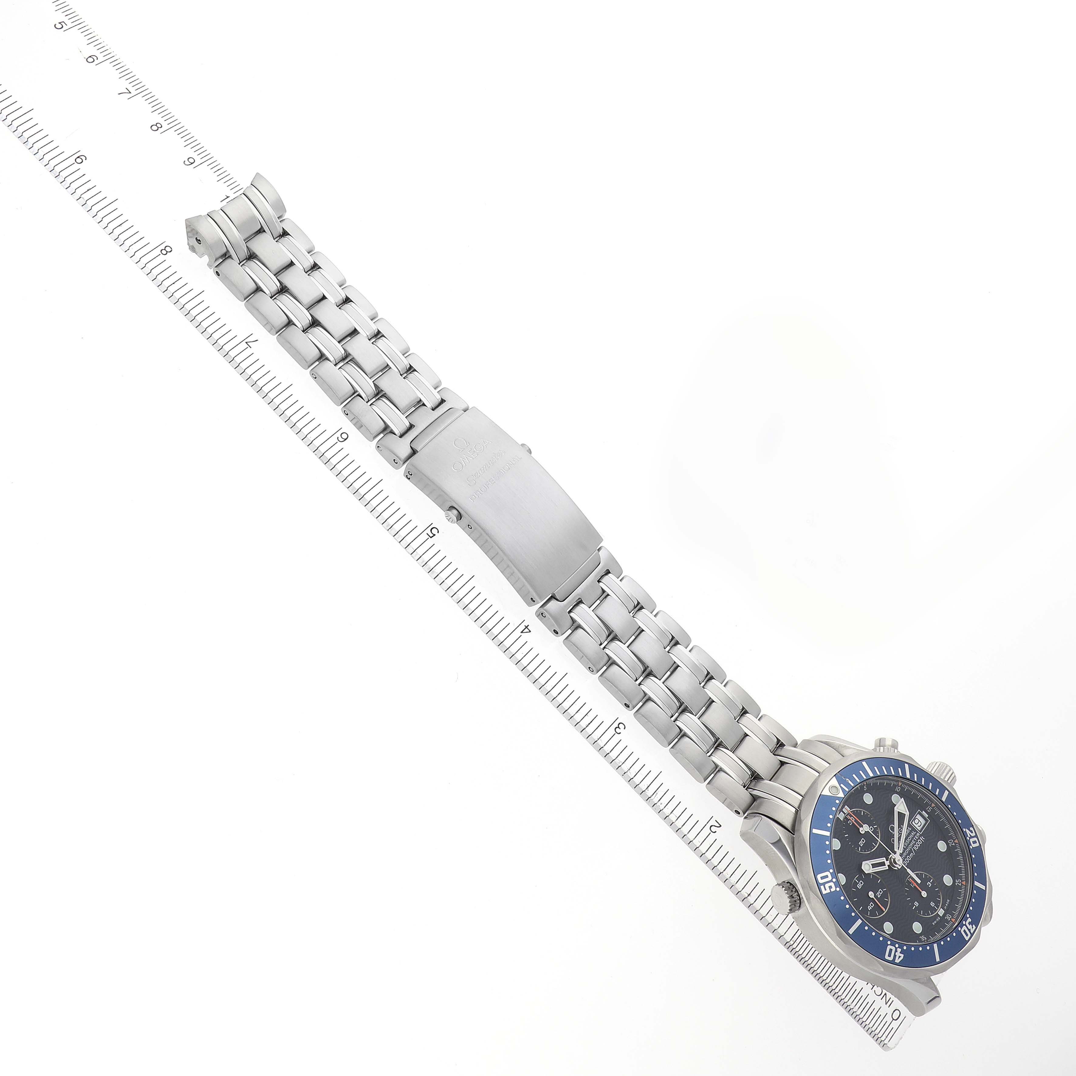 The image shows the Omega Seamaster model 2599.80.00 men's watch laid flat, highlighting the bracelet, clasp, and face, aligned along a ruler.