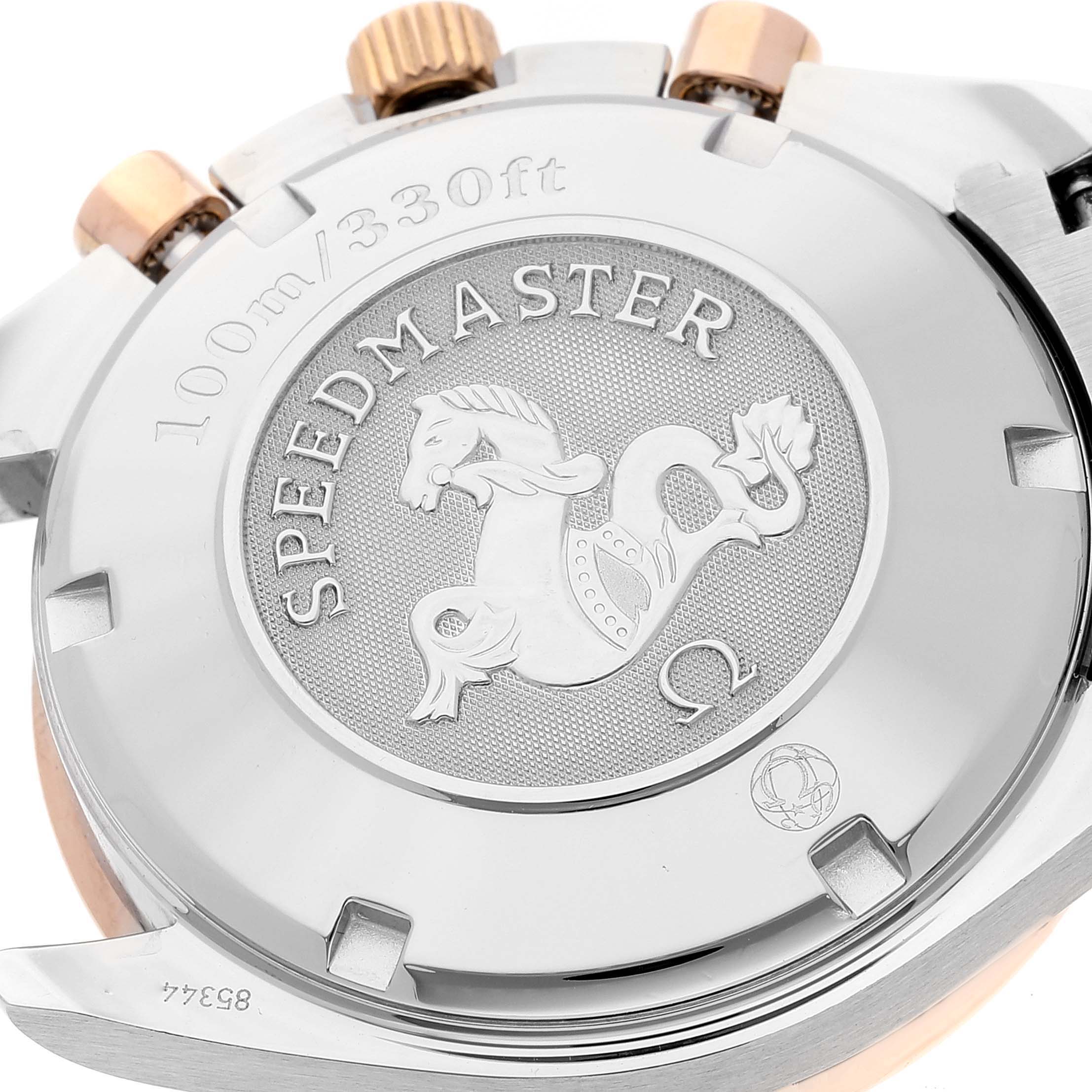 This image shows the case back of the Omega Speedmaster 323.21.40.40.01.001 Men's Steel and Gold (two tone) Black Dial 323.21.40.40.01.001 Men's Steel and Gold (two tone) Black Dial watch, highlighting the engraved emblem and the "100m/330ft" water resistance text.