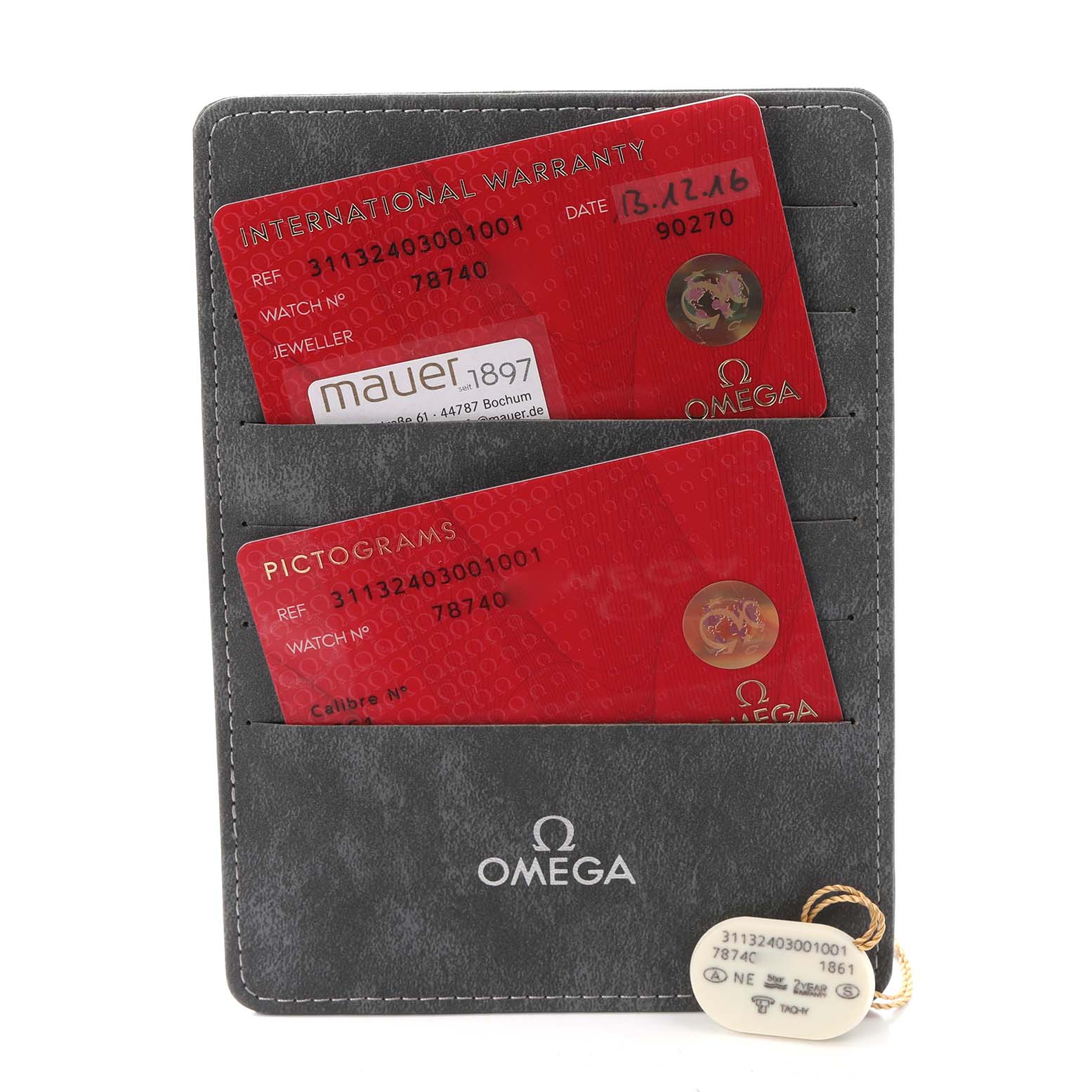 The image shows the warranty and pictogram cards for the Omega Speedmaster model 311.32.40.30.01.001, along with a tag displaying the same model number.