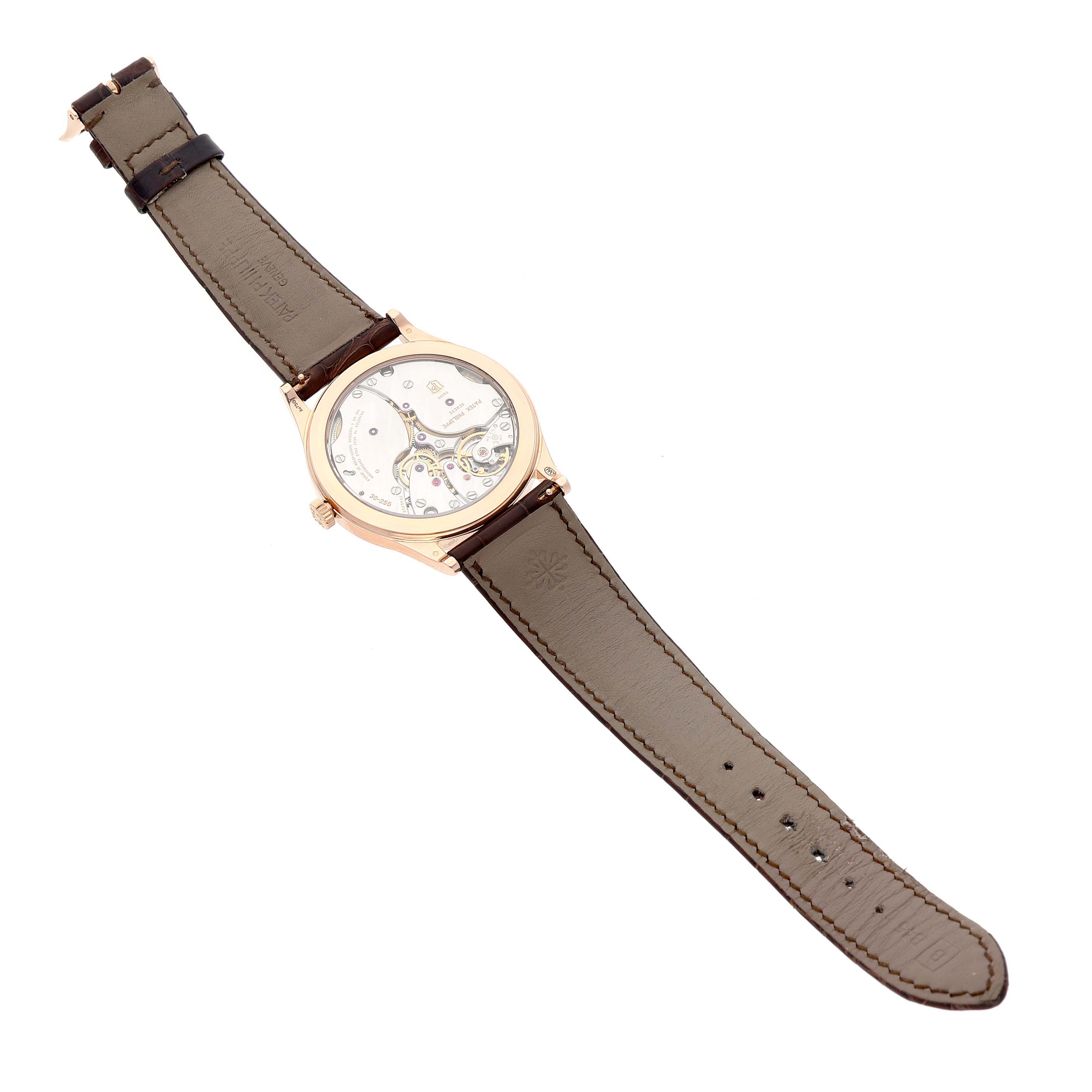 The Patek Philippe Calatrava 6119R-001 Men's Rose Gold Silver Dial watch is shown from a top-down angle, highlighting the open case back and leather strap.