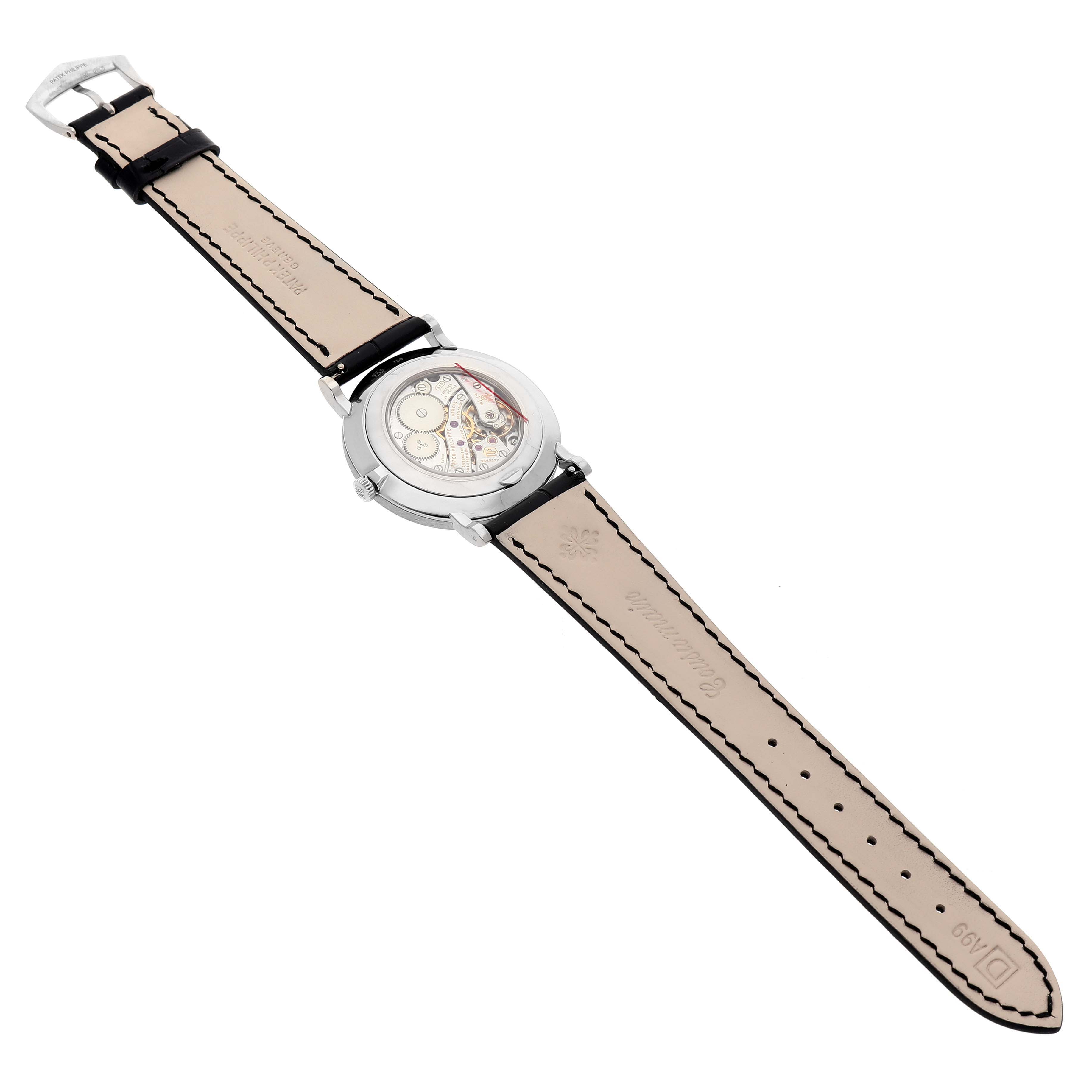 The Patek Philippe Calatrava 5116G-001 Men's White Gold White Dial watch is shown from the back, showcasing the inner mechanics and leather strap.