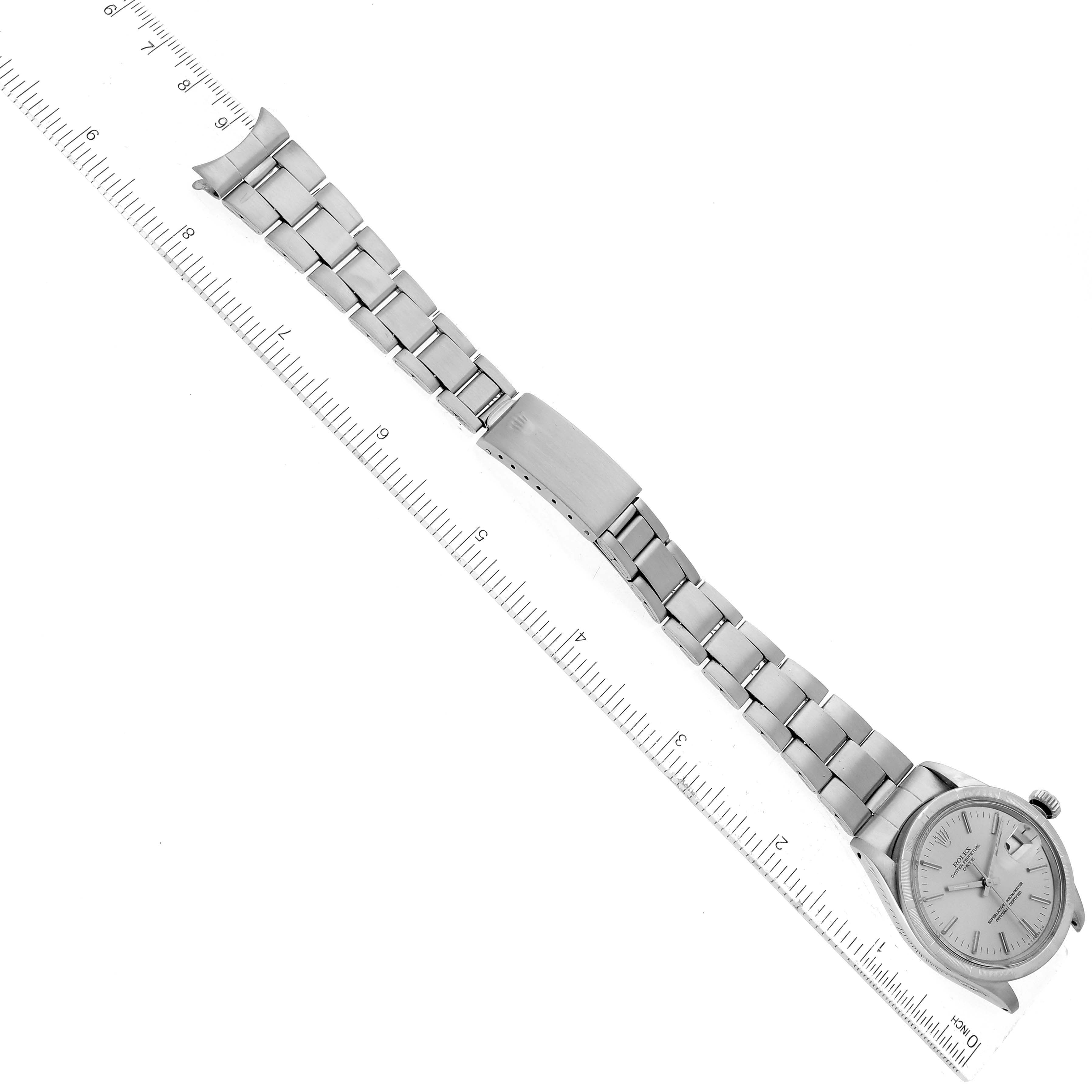 The image shows a Rolex Date 1501 Men
s Stainless Steel Silver Dial 1501 Men
s Stainless Steel Silver Dial model watch laid flat with a ruler beneath it, displaying the entire bracelet and face from above.