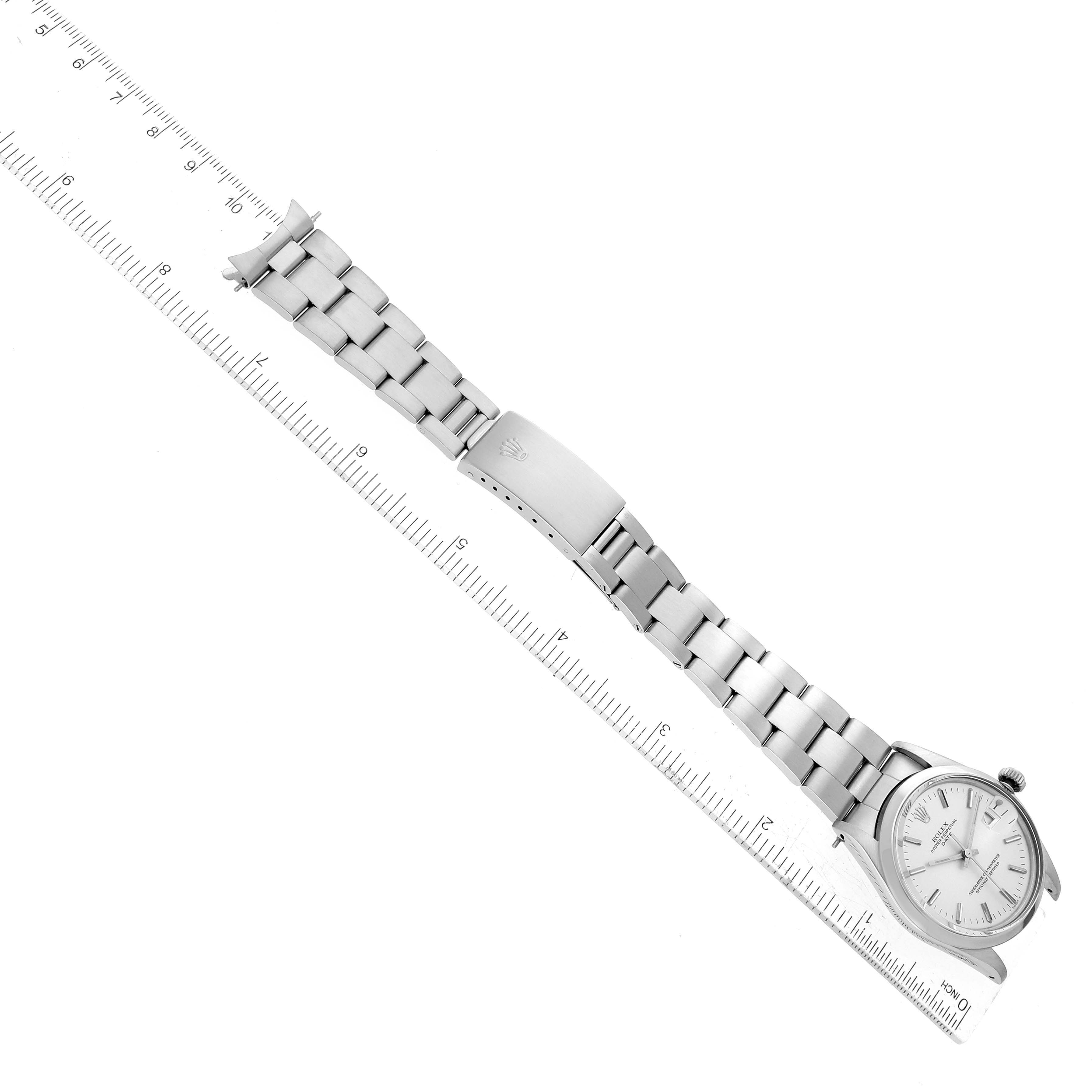 This image shows the Rolex Vintage Collection 15000 Men's Stainless Steel Silver Dial 15000 Men's Stainless Steel Silver Dial watch laid flat next to a ruler, displaying its face, bracelet, and clasp.