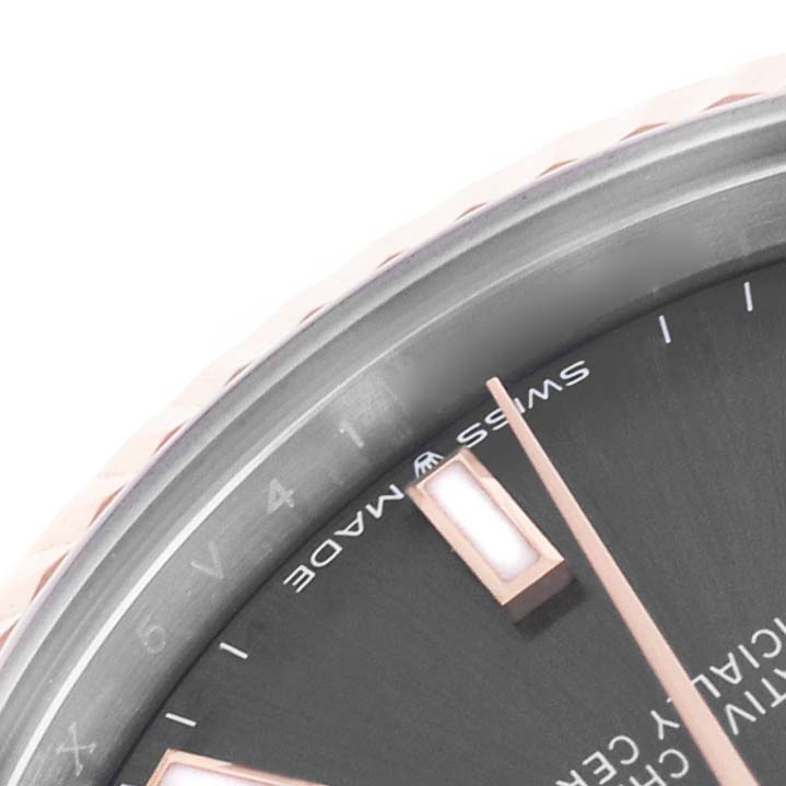 The image shows a close-up of the bezel and part of the dial with indices and hands of the Mid-Size Rolex watch.
