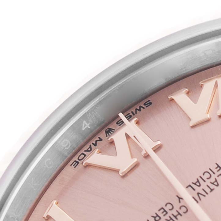 The image shows a close-up of the face and bezel of a Mid-Size Rolex watch, highlighting the Roman numeral and "Swiss Made" text.